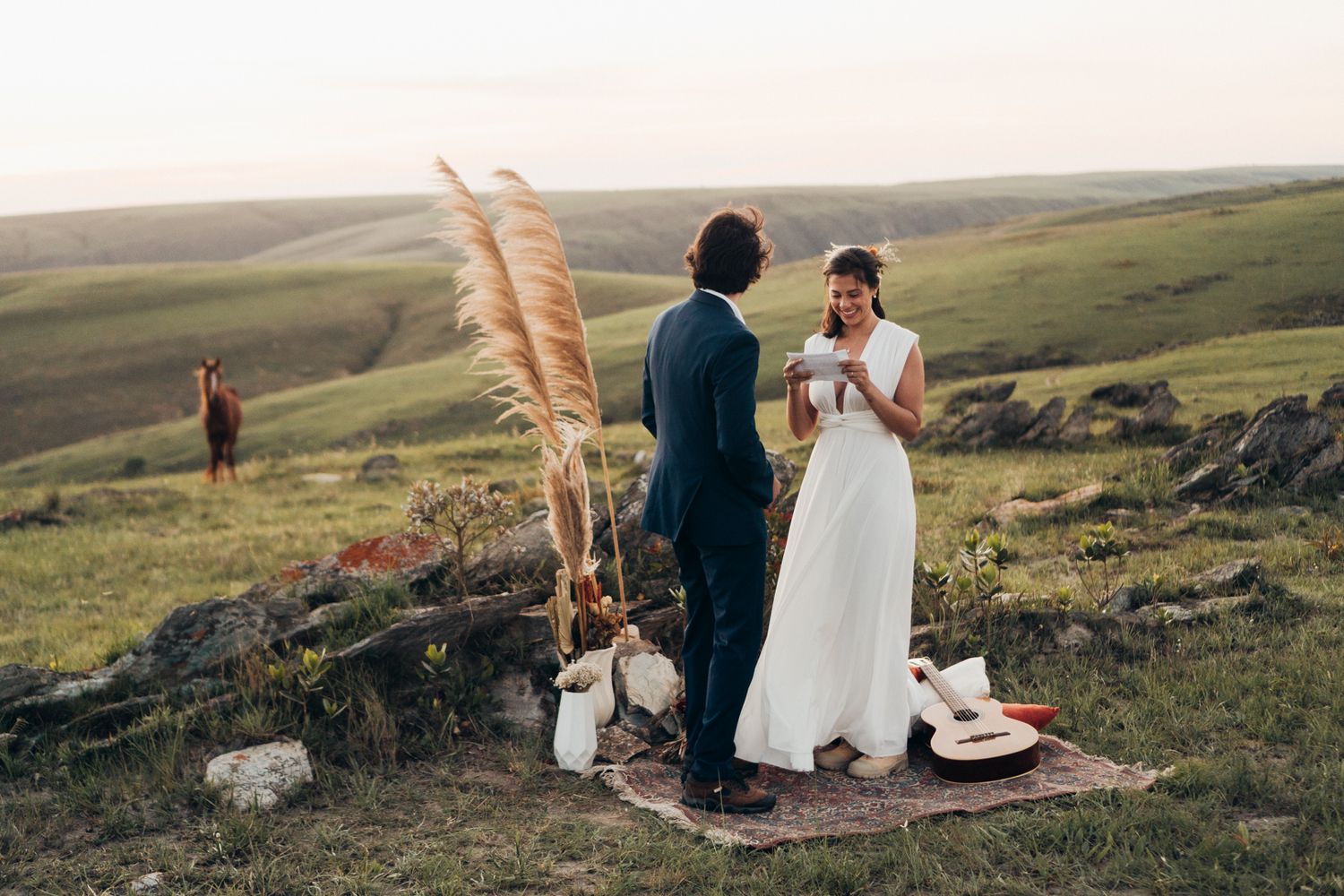 Noiva lê seus votos em elopement nos campos da Serra da Canastra com cavalo ao fundo © Clara e Matheus Fotógrafos para Casamentos
