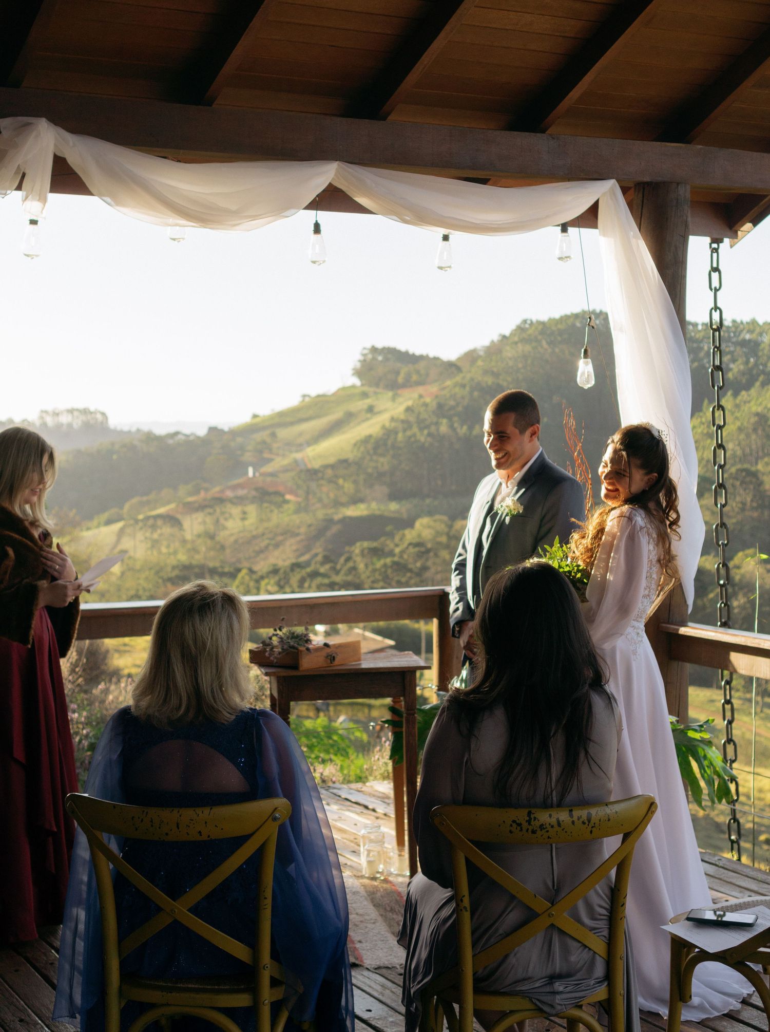 An intimate wedding ceremony unfolds on a deck with stunning mountain vistas in the background.
