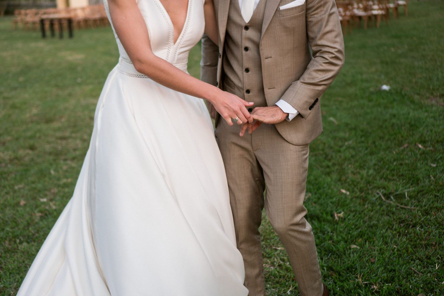Casal segurando as mãos em cerimônia de casamento ao ar livre, fotografia documental de Clara e Matheus fotógrafos de casamento