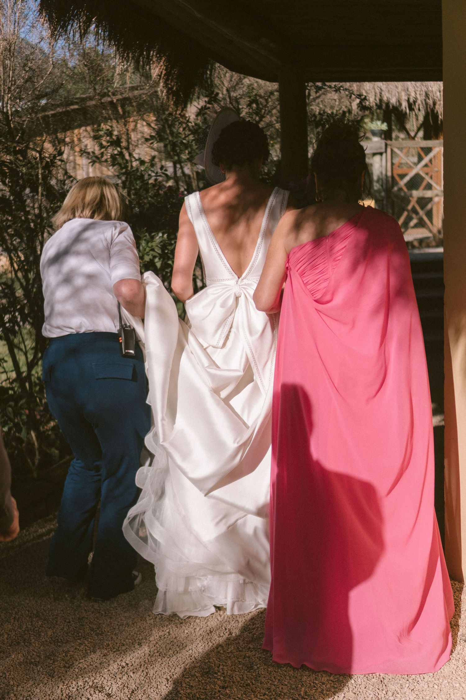 Alegria e romance: noiva e madrinhas caminhando juntas em um casamento ao ar livre, vestindo branco e rosa