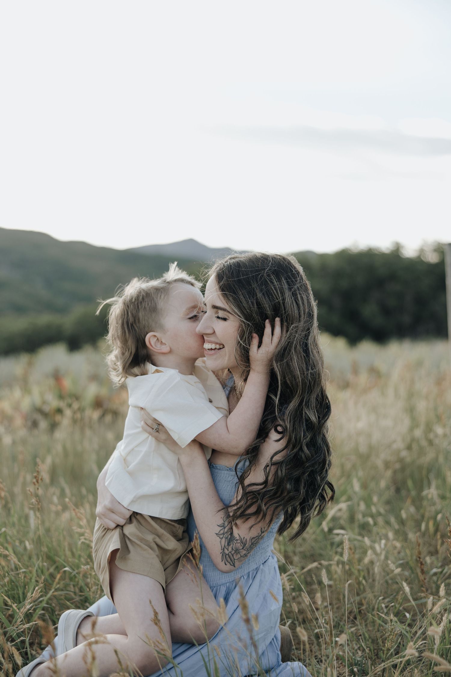 A tender moment shared between parent and child in a sun-drenched meadow at golden hour.