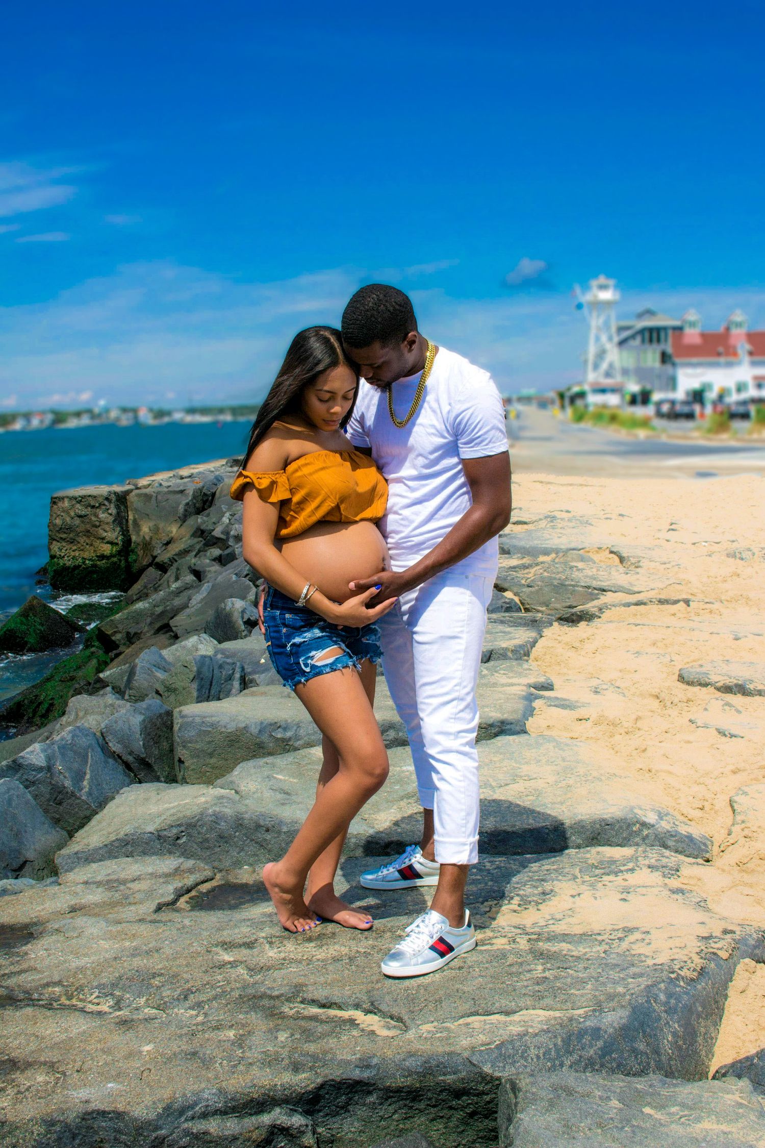 A romantic beachside photoshoot on rocky shores with crashing waves.  L Visions Photography. Lifestyle photoshoot. Maternity photoshoot