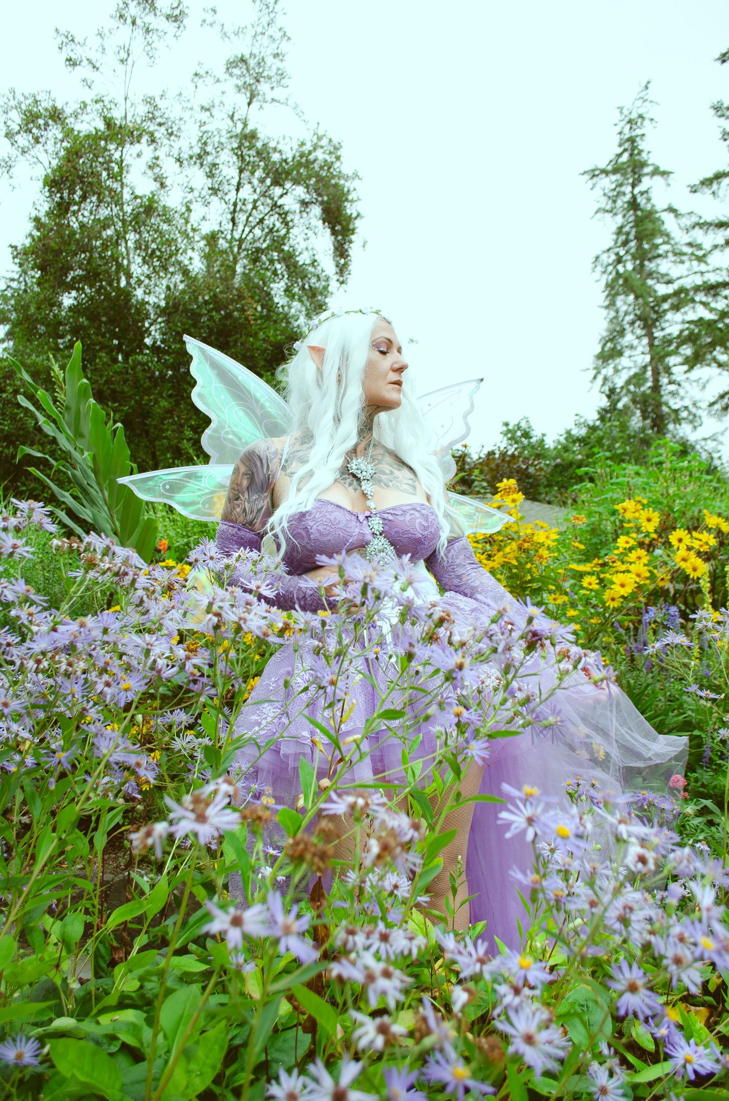 A photo of a fairy enjoying the abundance of flowers.