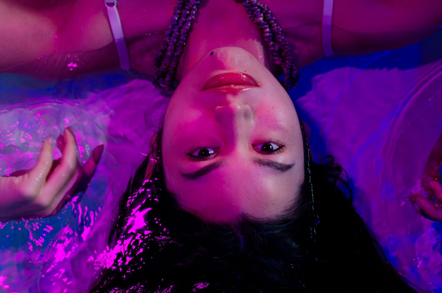 Experimental water shoot. Purple & blue LED lights with a pool at an indoor studio.
