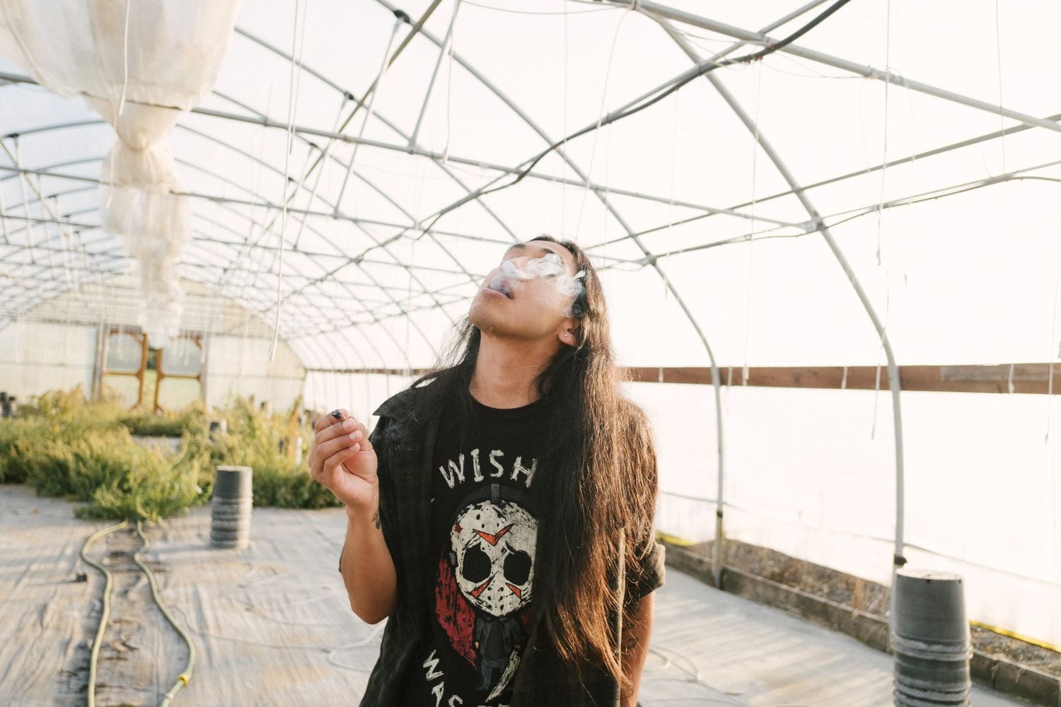 Photo of me smoking in a greenhouse.