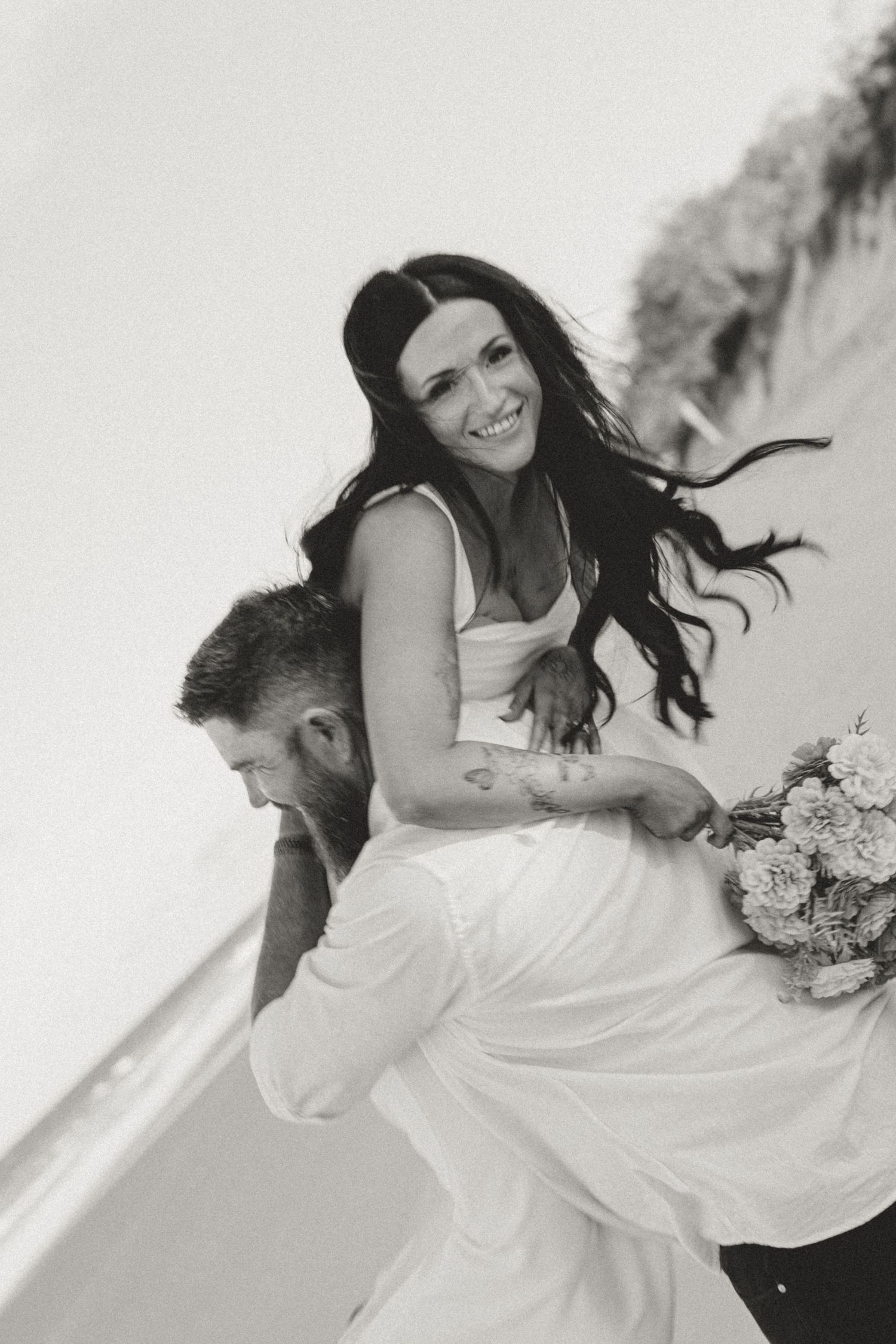 A couple shares a romantic moment while lying on a beach.