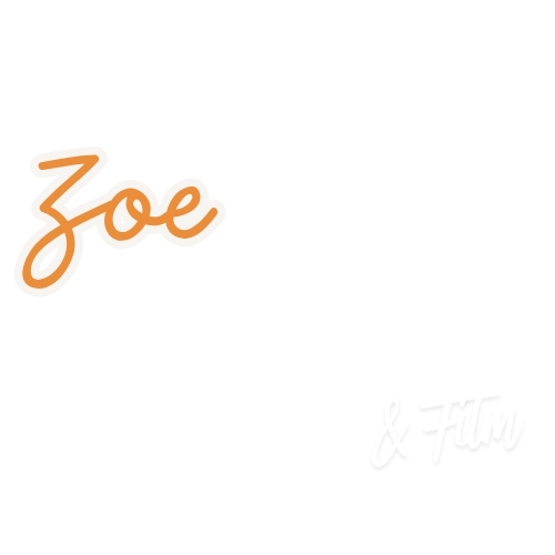 Orange neon sign spelling Zoe in cursive script on white background with small text signature.