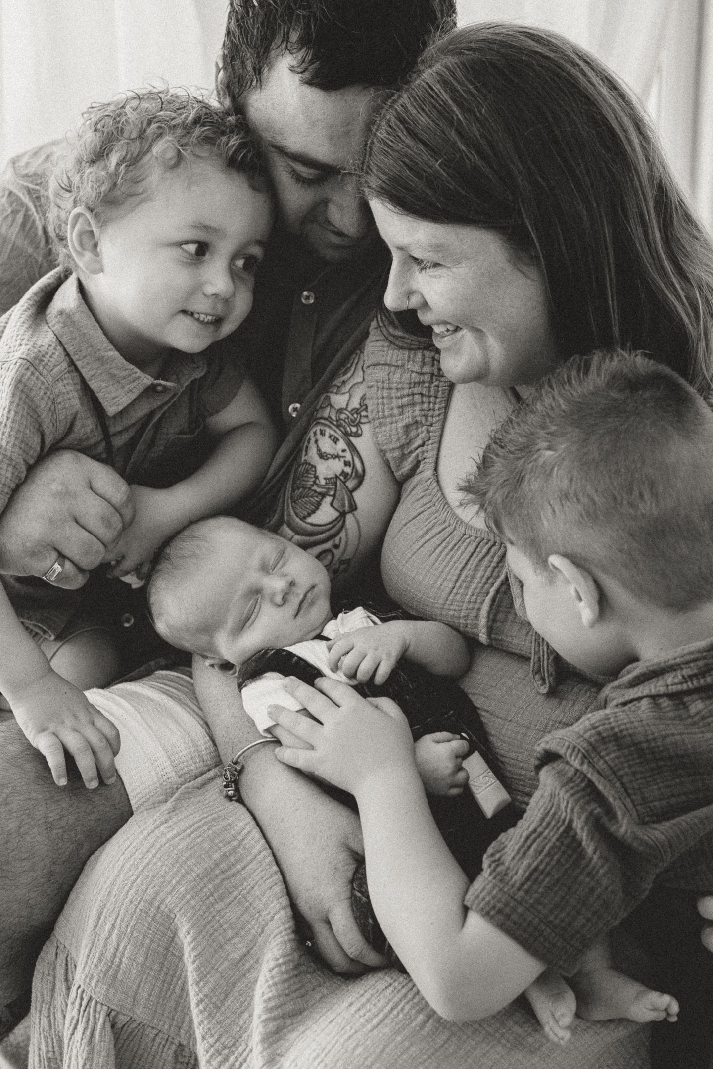 A series of black and white photos showing tender family moments of affectionate embraces and cuddles.