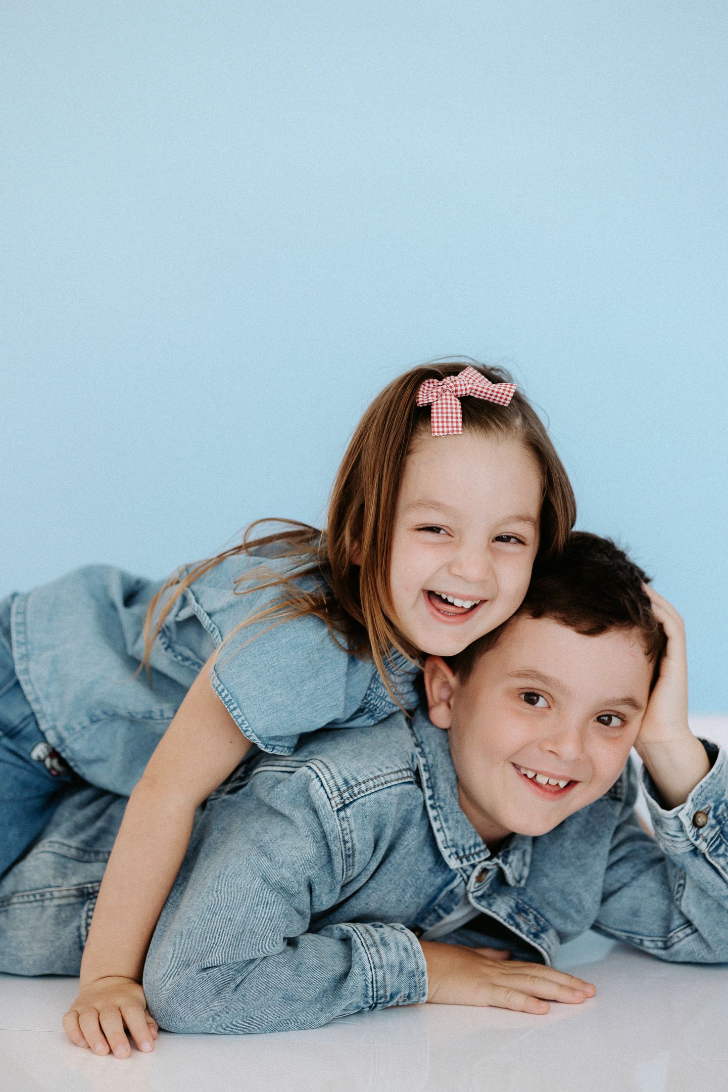 A playful sequence of poses on a light background showing joyful expressions and denim clothing.