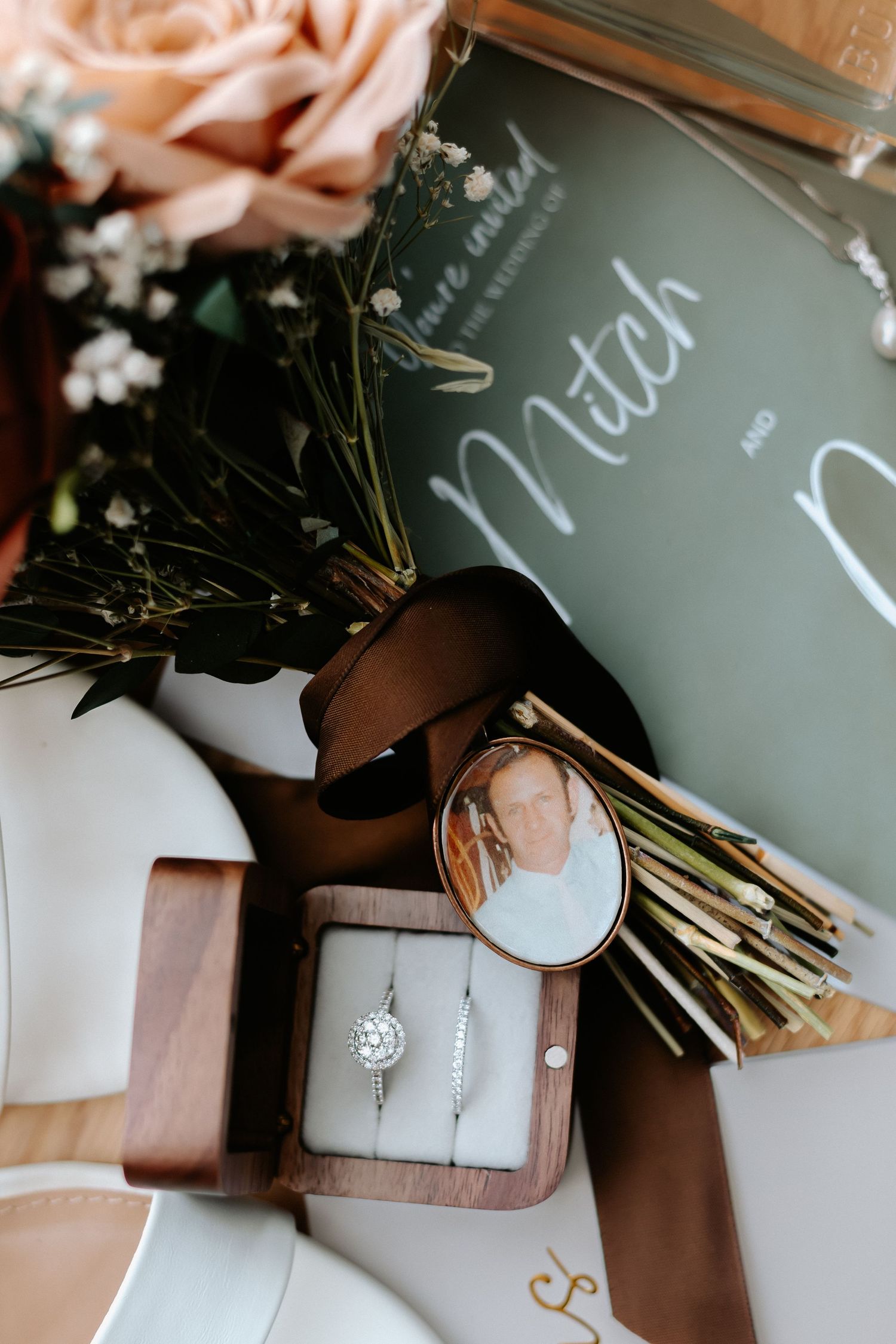 Wedding details featuring delicate pink ribbons and handwritten chalkboard signs.