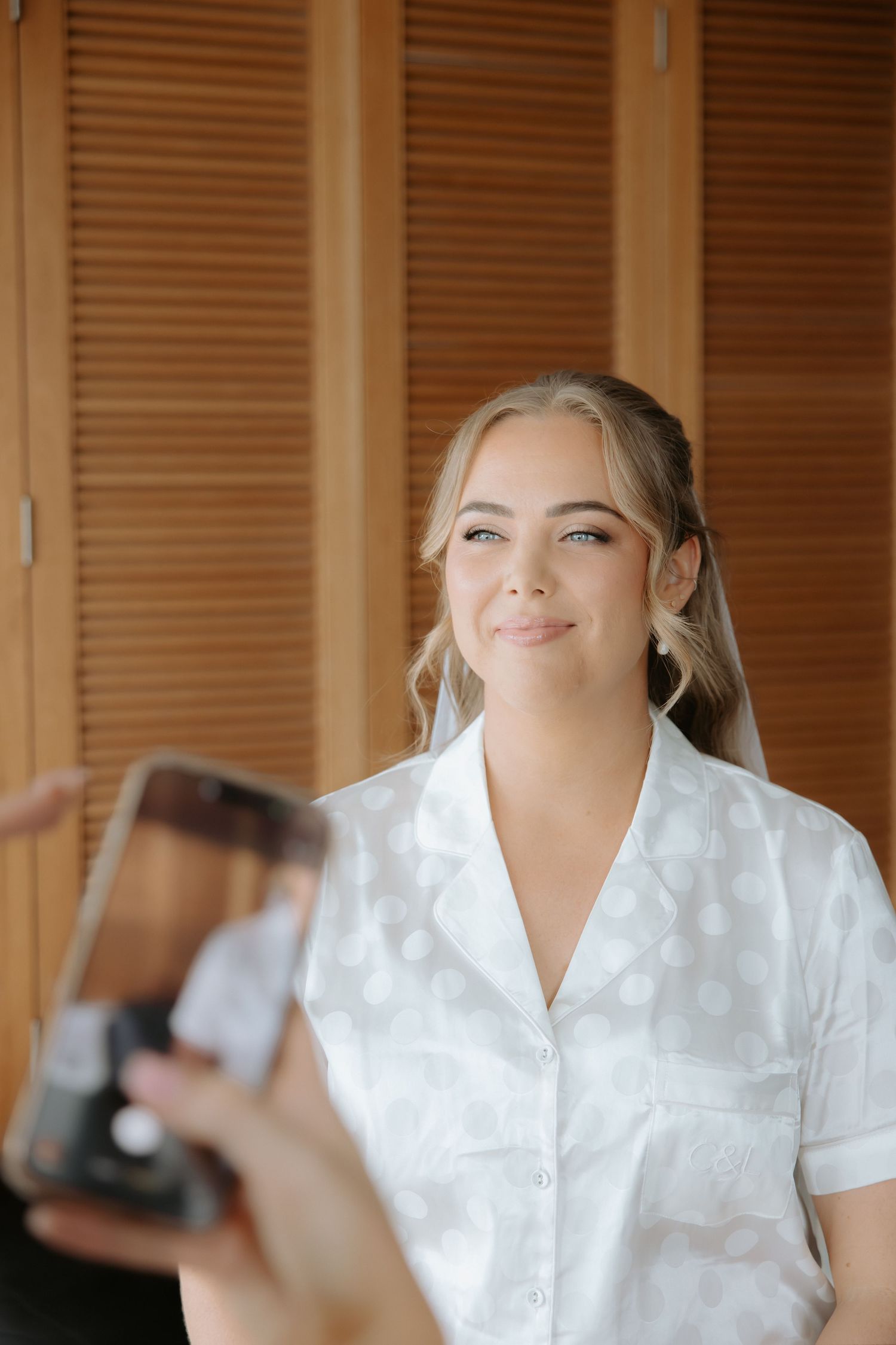 A person wearing a white button-up shirt looks upward with a serene expression in a warm-lit room.
