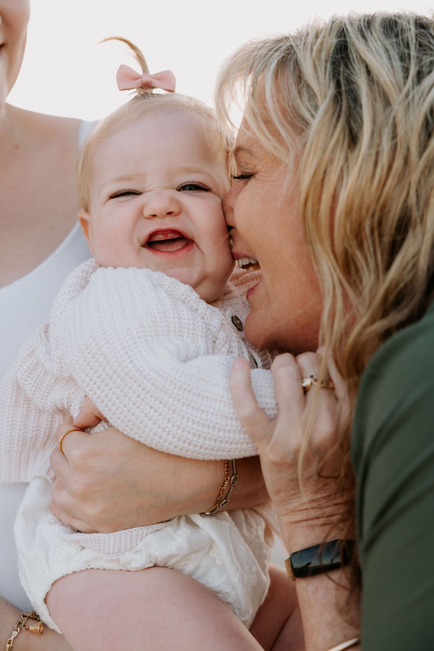 A tender moment shared between a baby in a white knit sweater and someone holding them in a loving embrace.