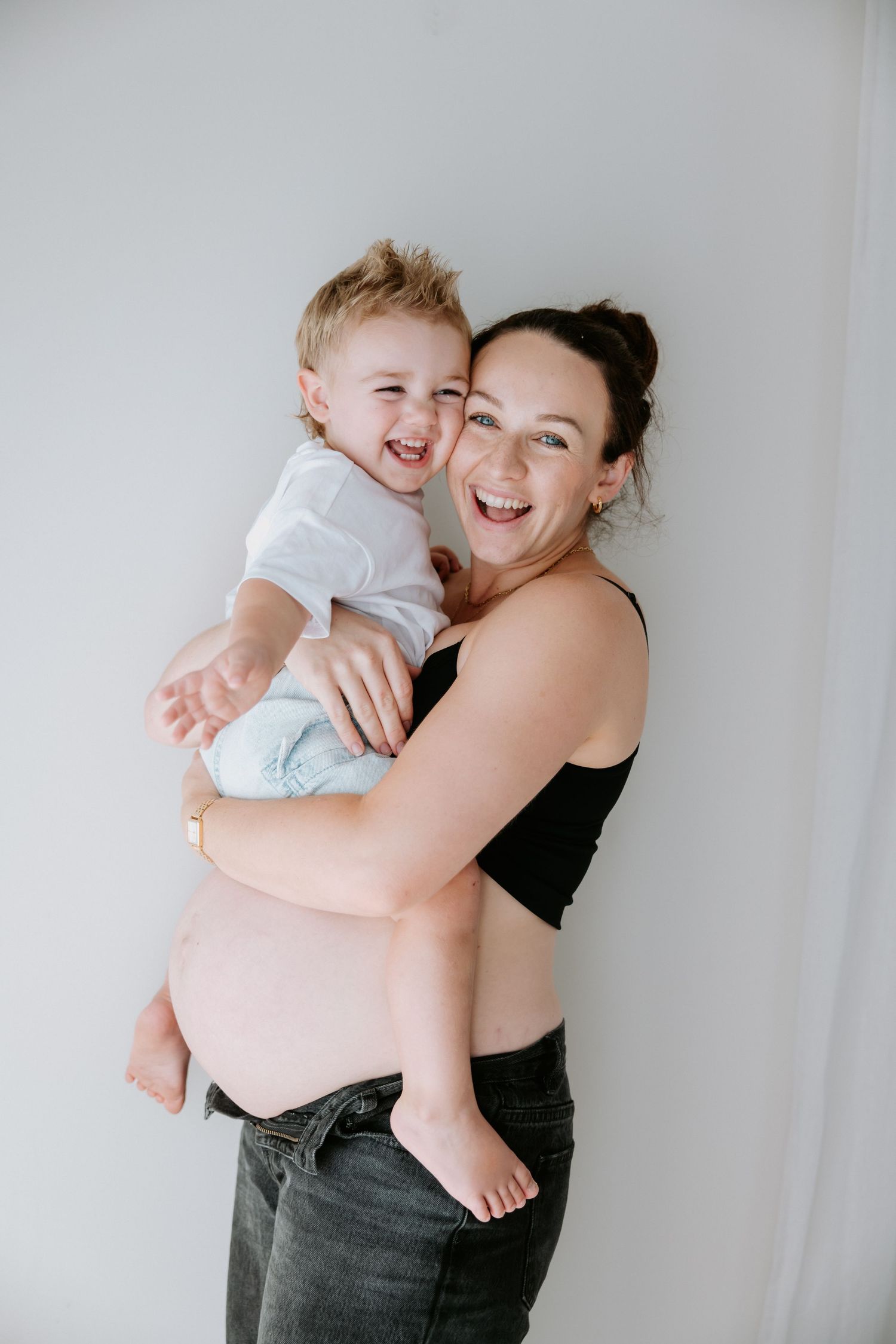A joyful moment captured in black and white showing tender embraces and laughter against a light background.