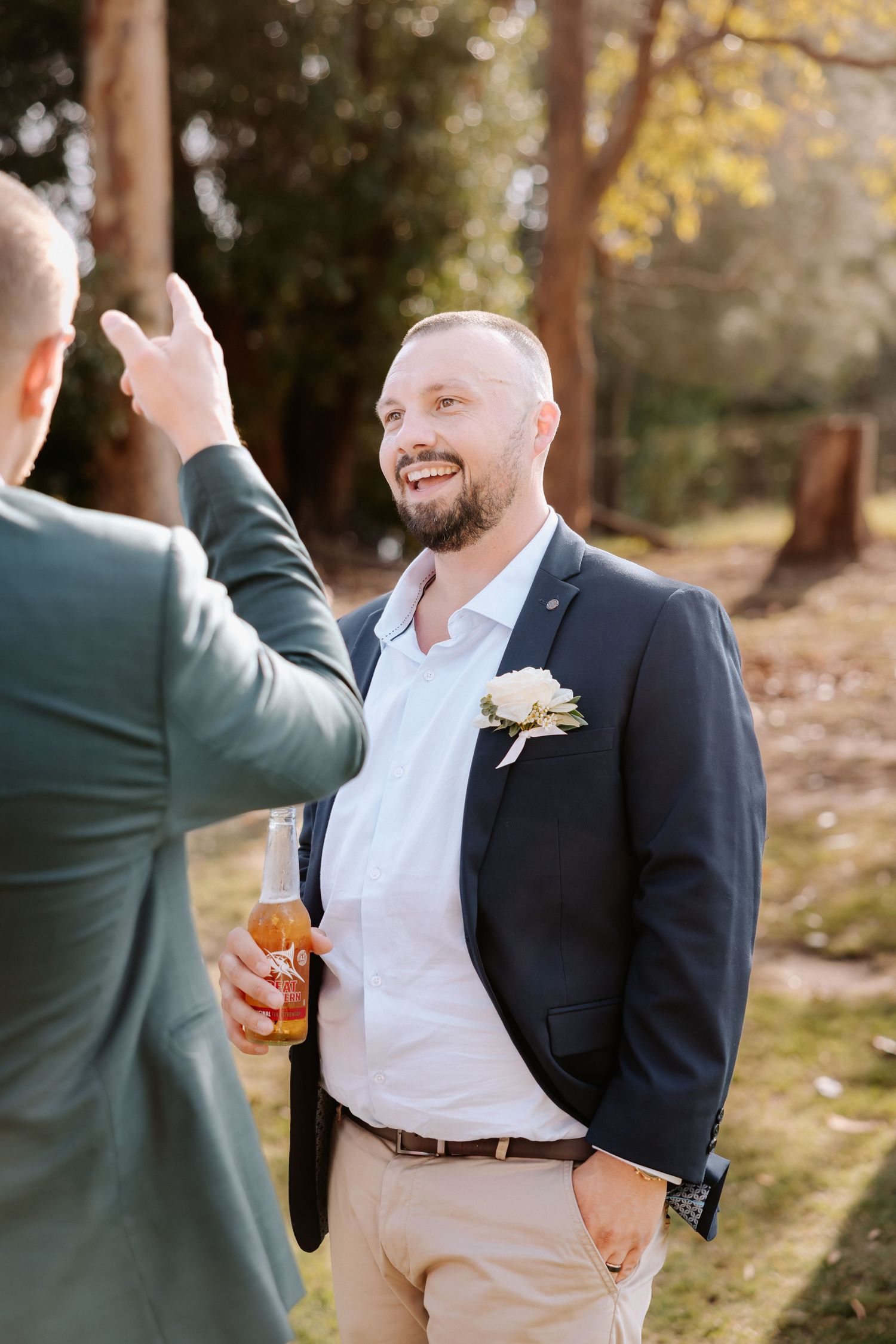 Wedding guests enjoying drinks and conversation in warm autumn sunlight.