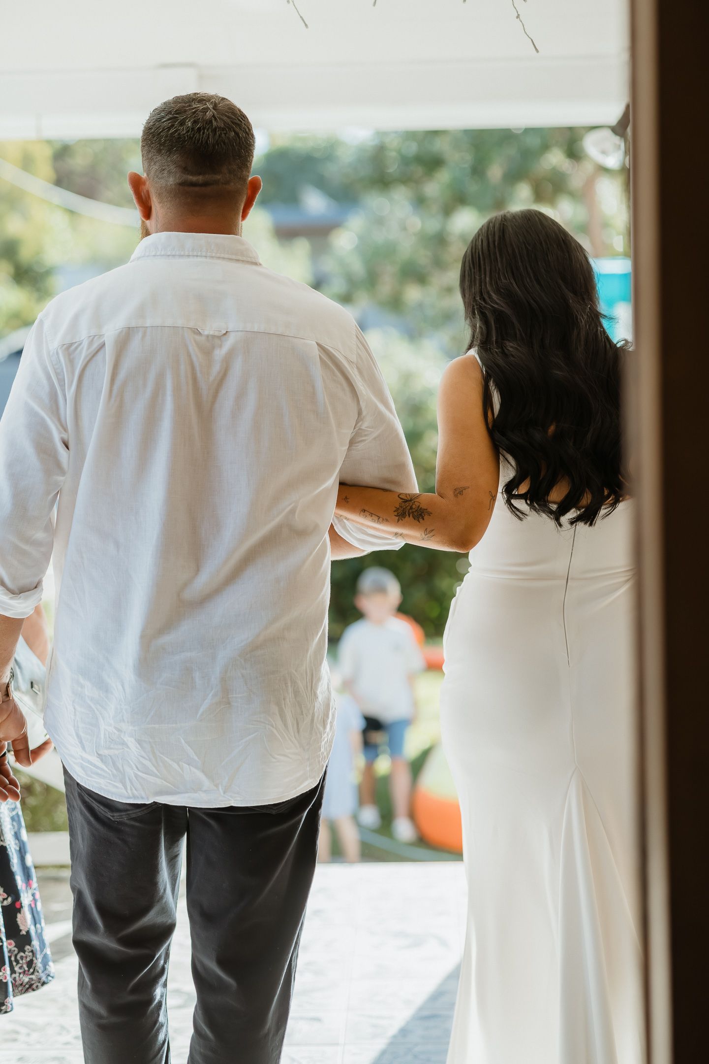 Group of people dressed in white and gray clothing walking together in an indoor venue.