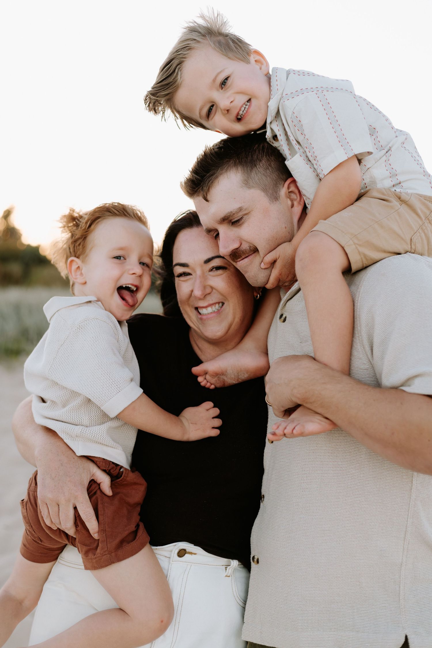 A candid family photo series shows joyful moments of playful interaction and embraces at sunset.