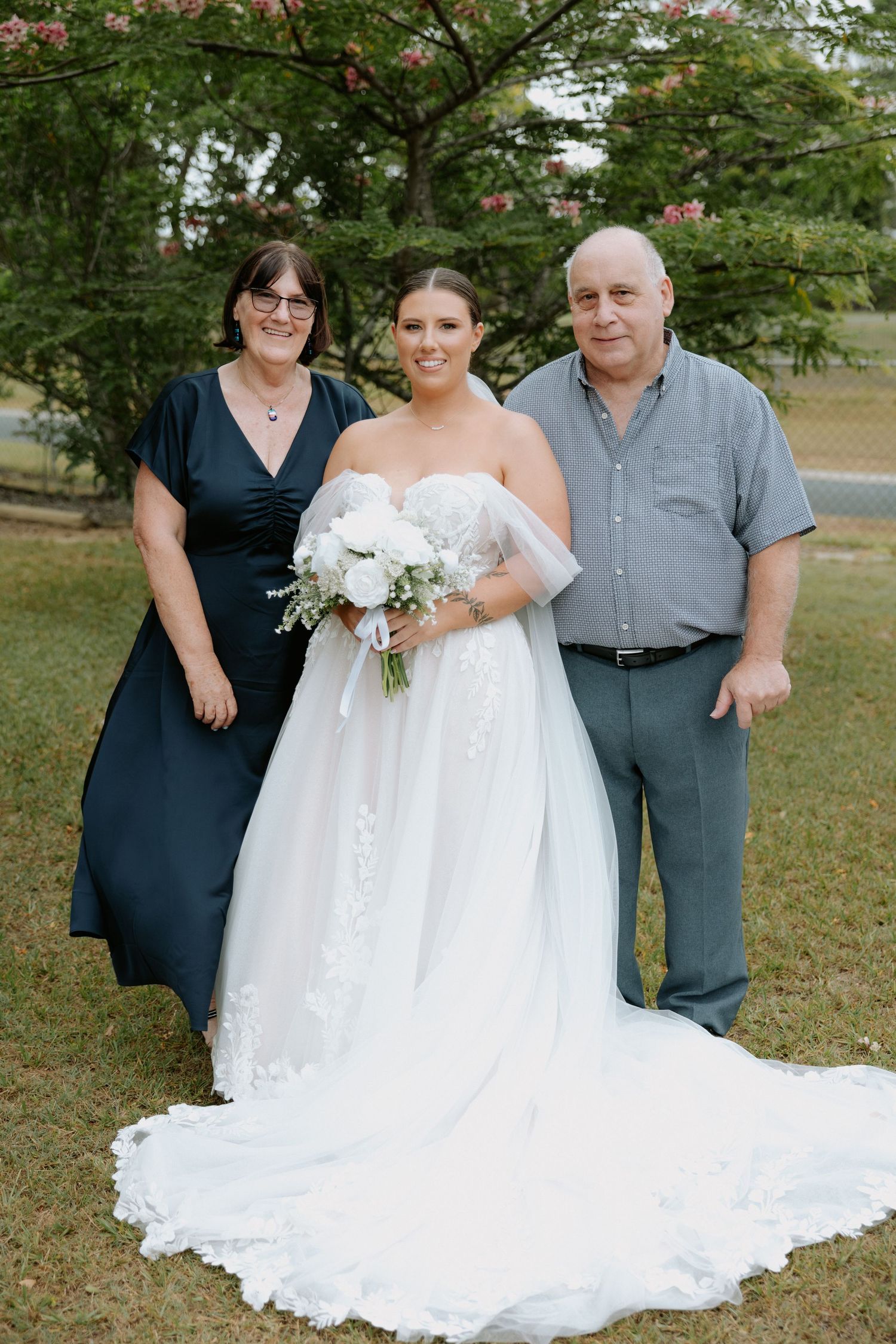 Outdoor wedding portrait with beautiful white gown and natural garden setting.