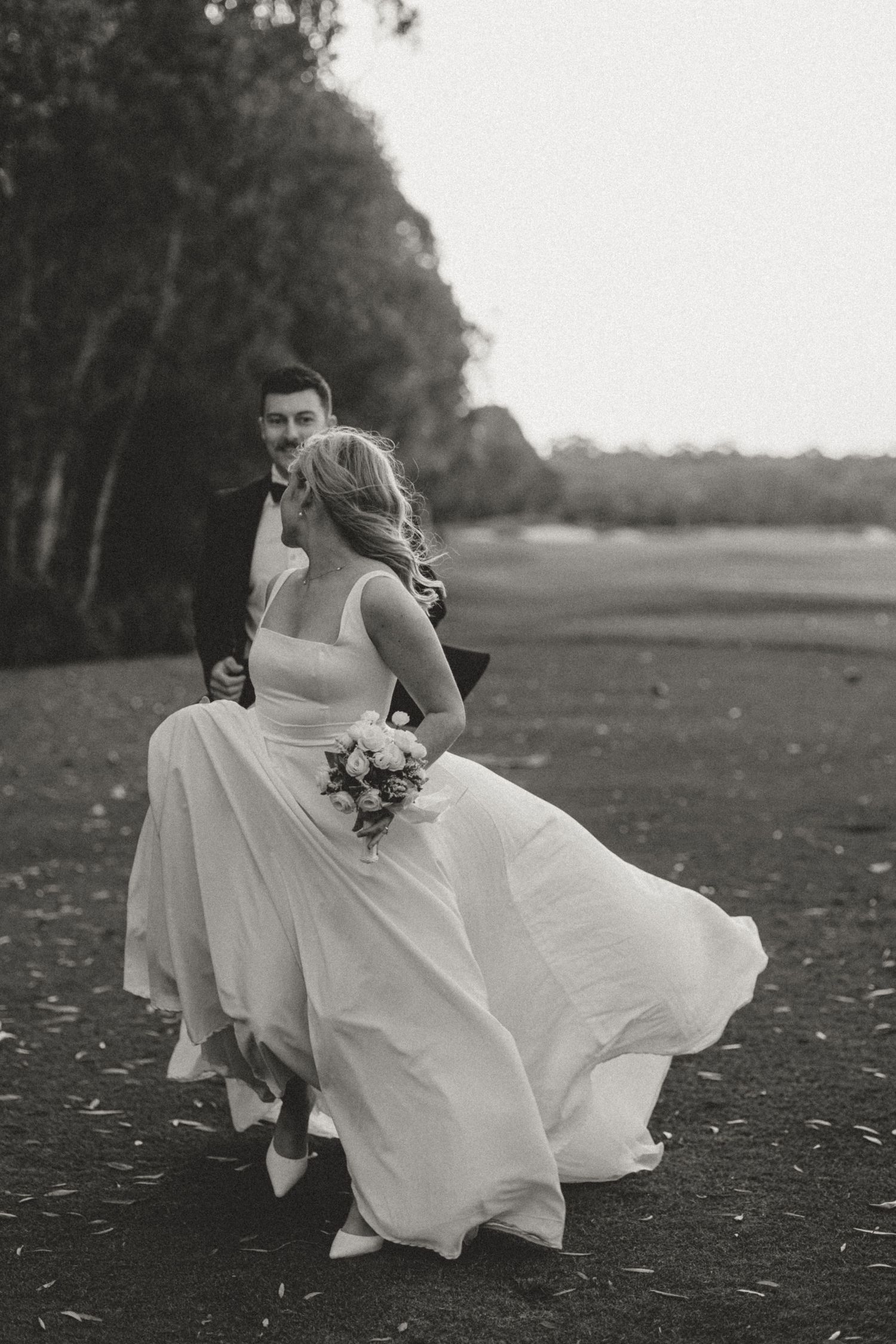 Black and white photos of bride running through field with dress flowing behind.