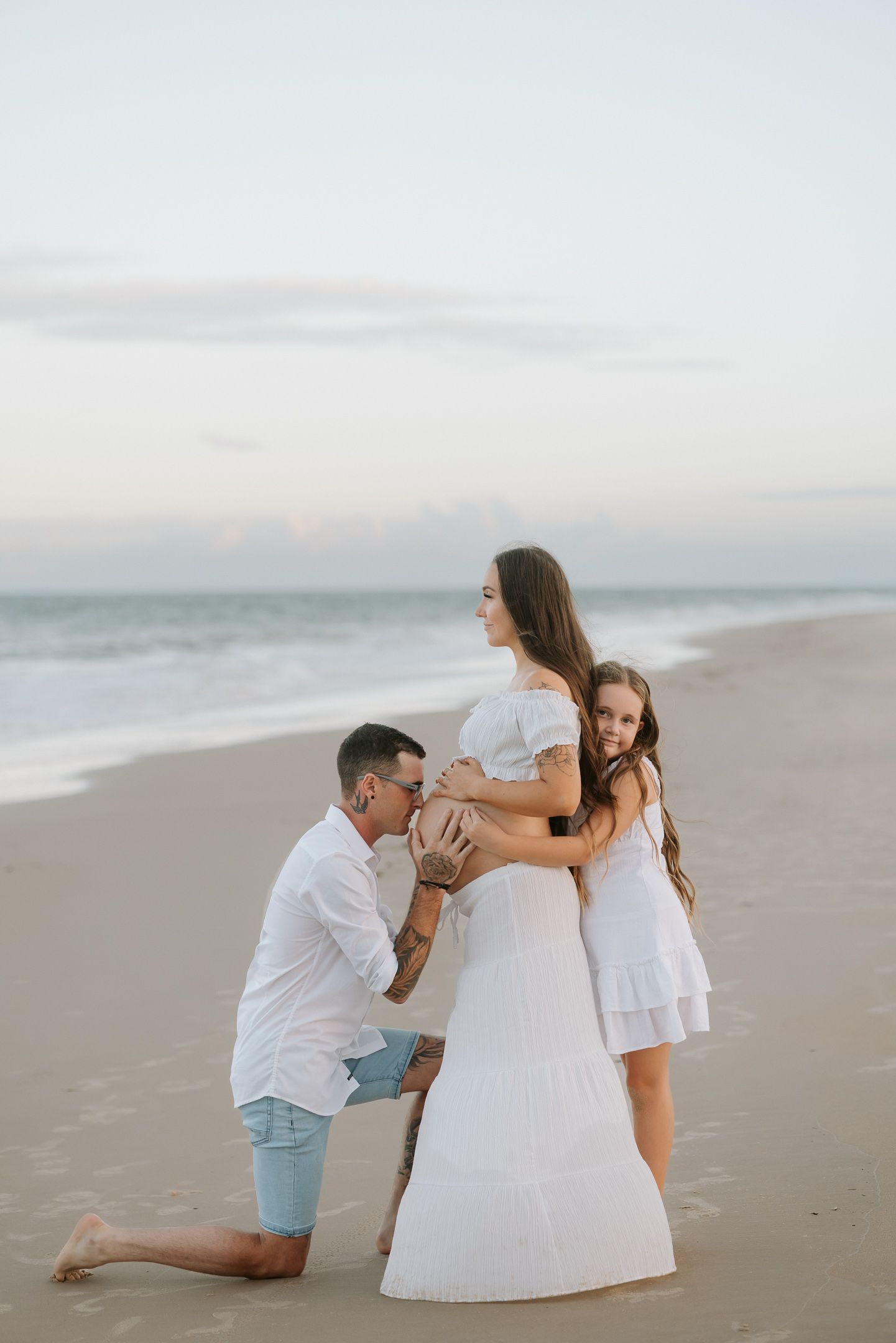A romantic beach proposal sequence shows a couple in white outfits during a sunset engagement photoshoot.