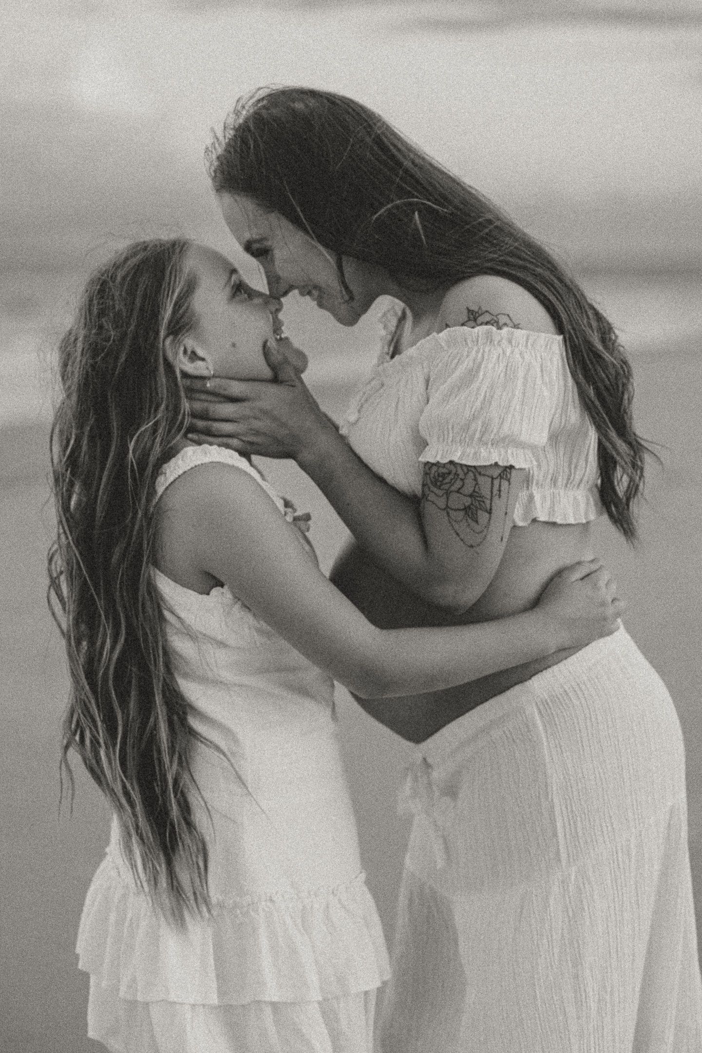 A romantic black and white photo sequence shows a couple in white clothing embracing and kissing on the beach.