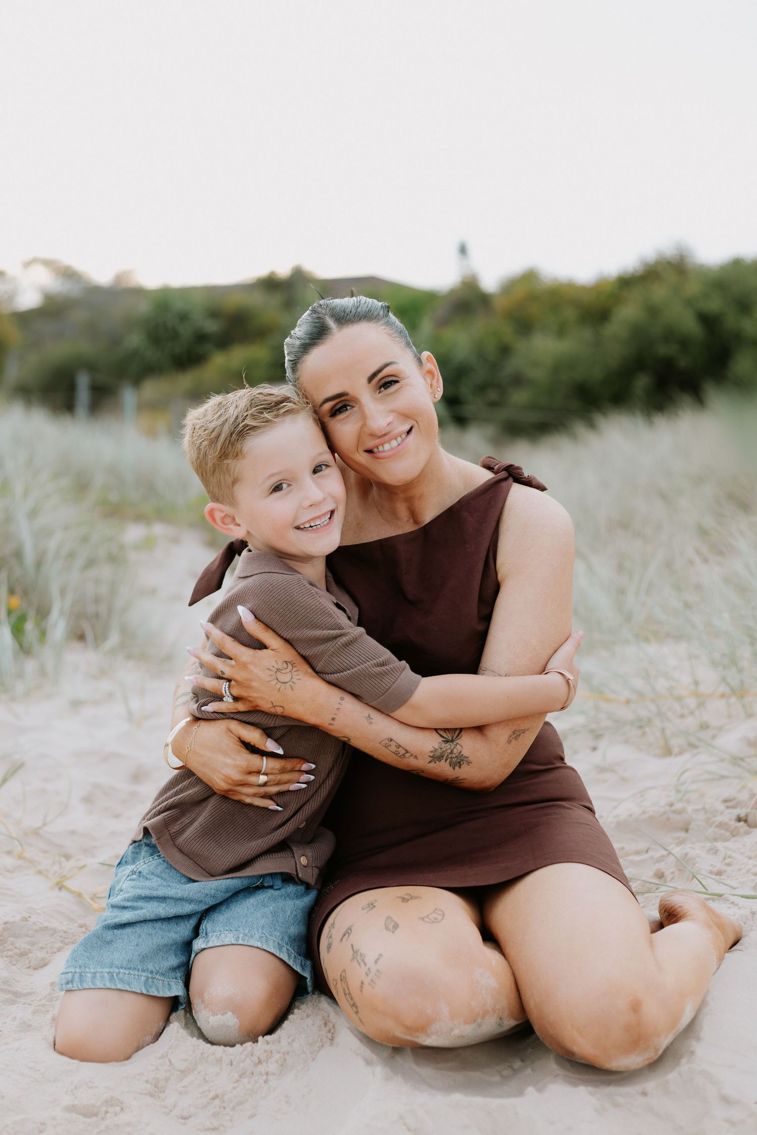 A series of heartwarming beach photos showing tender embraces between parent and child in casual attire on sandy dunes.