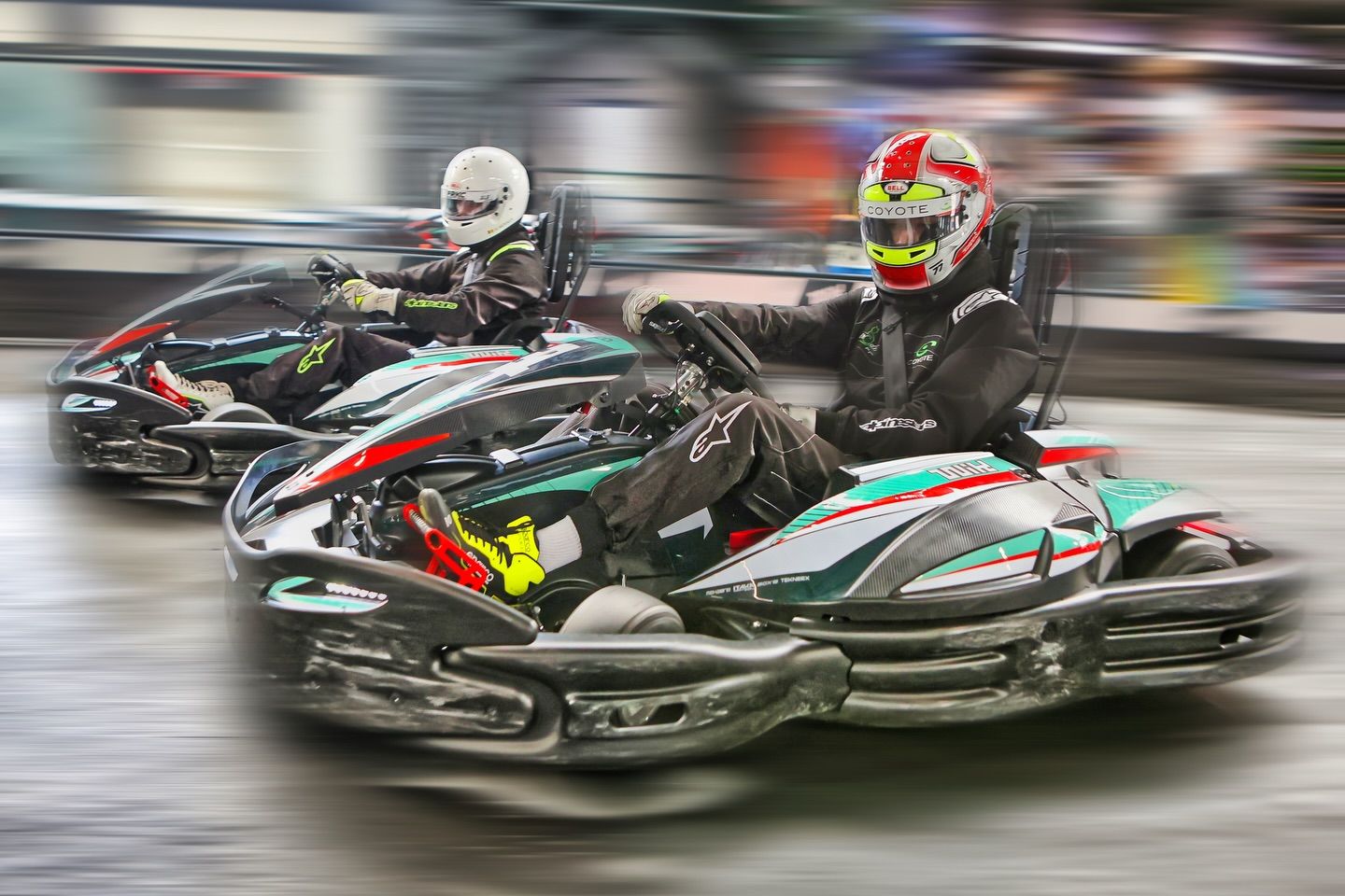 Go-karts racing at high speed captured with motion blur effect showing intense competition.