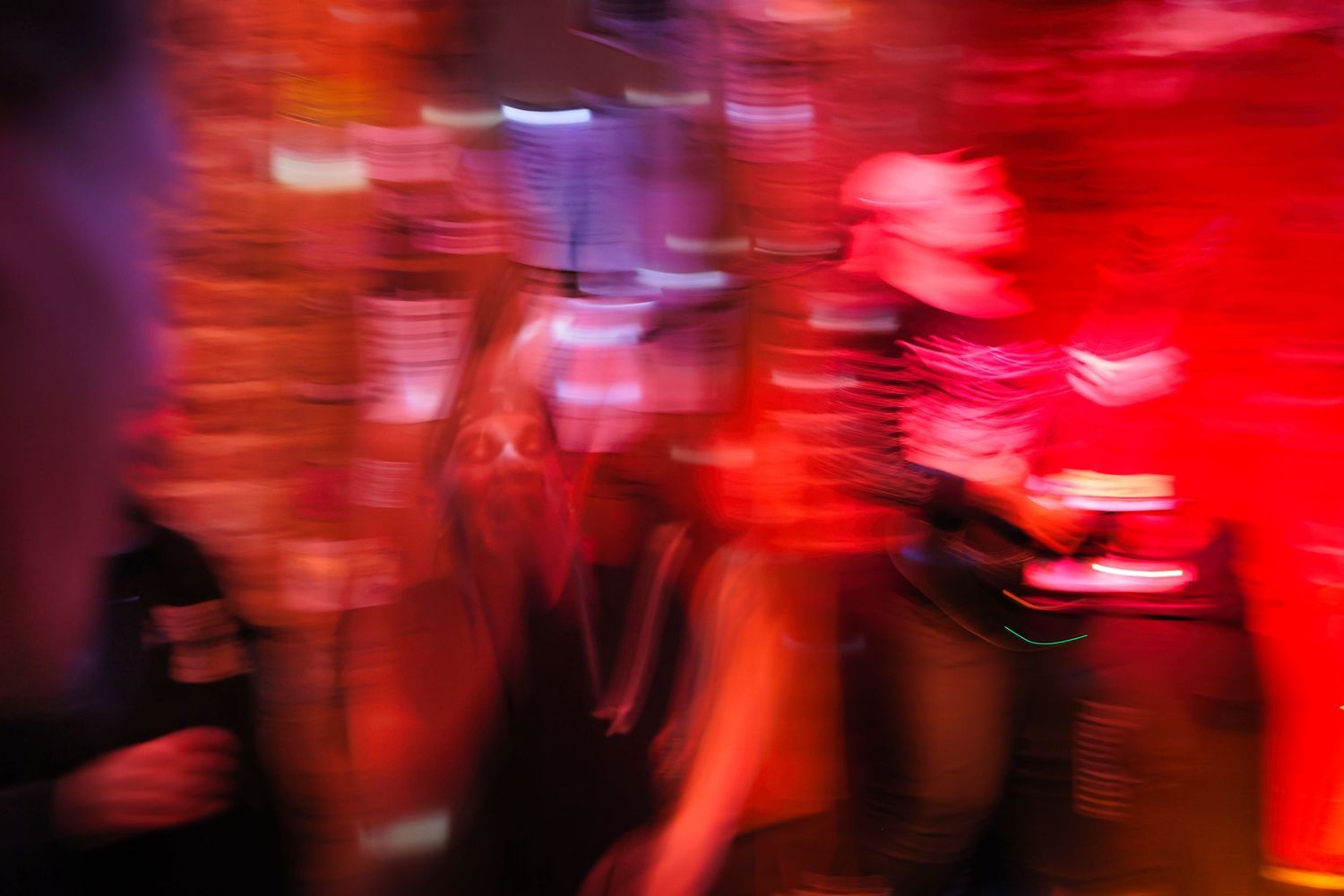 Abstract motion-blurred scene with red lighting creating a dynamic atmosphere.
