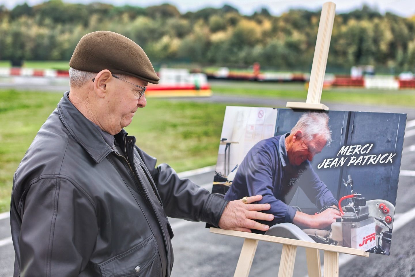 Person in dark jacket examining a memorial photo display outdoors.