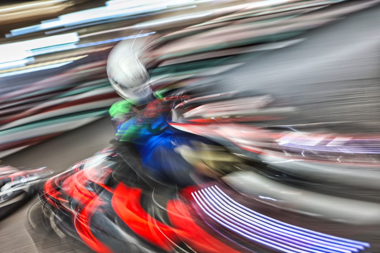 Motion blur effect showing speed of go-karts with red and white streaks.