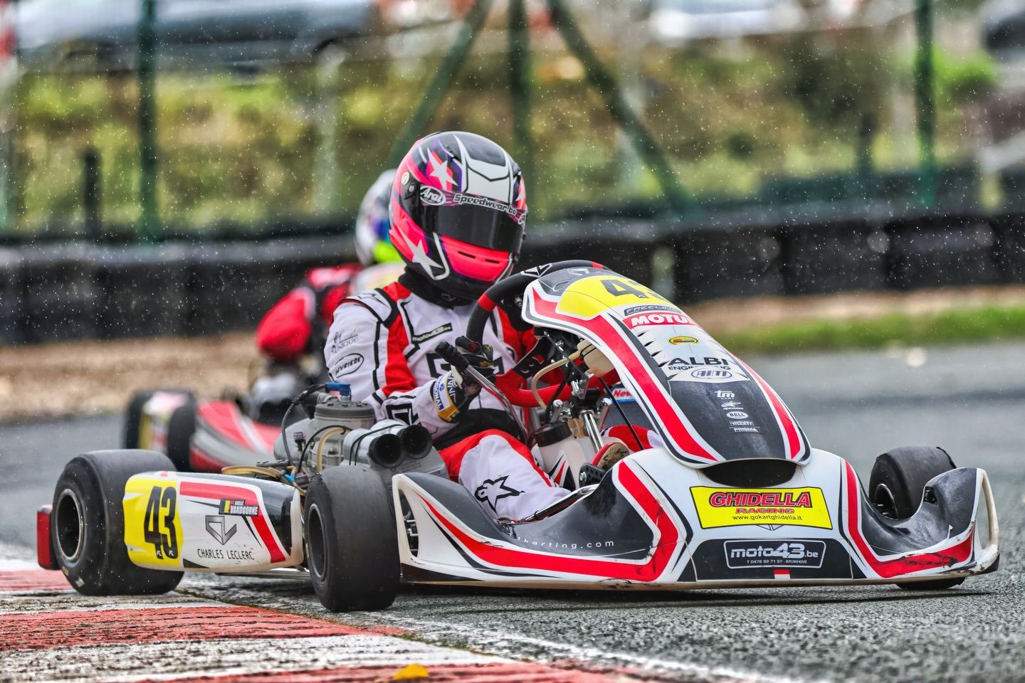 Low angle view of go-karts racing closely together on an outdoor karting circuit.