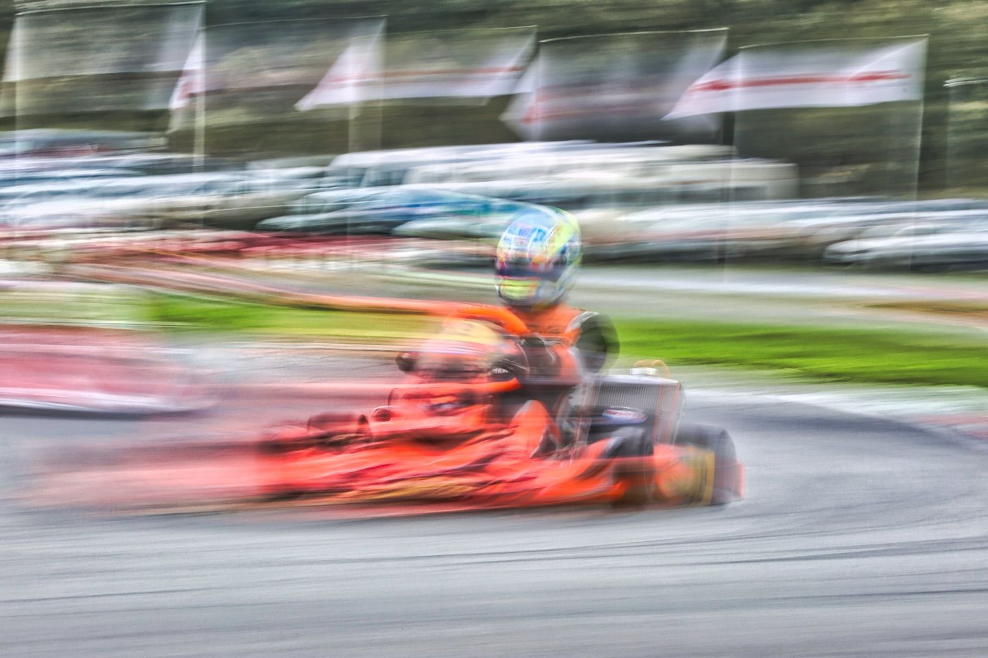 Motion blurred go-karts racing at high speed creating dramatic streaks of color.