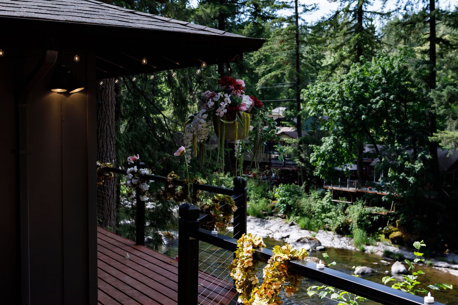 A wedding ceremony setting in a wooded area with chairs arranged in front of trees and rustic decorations.