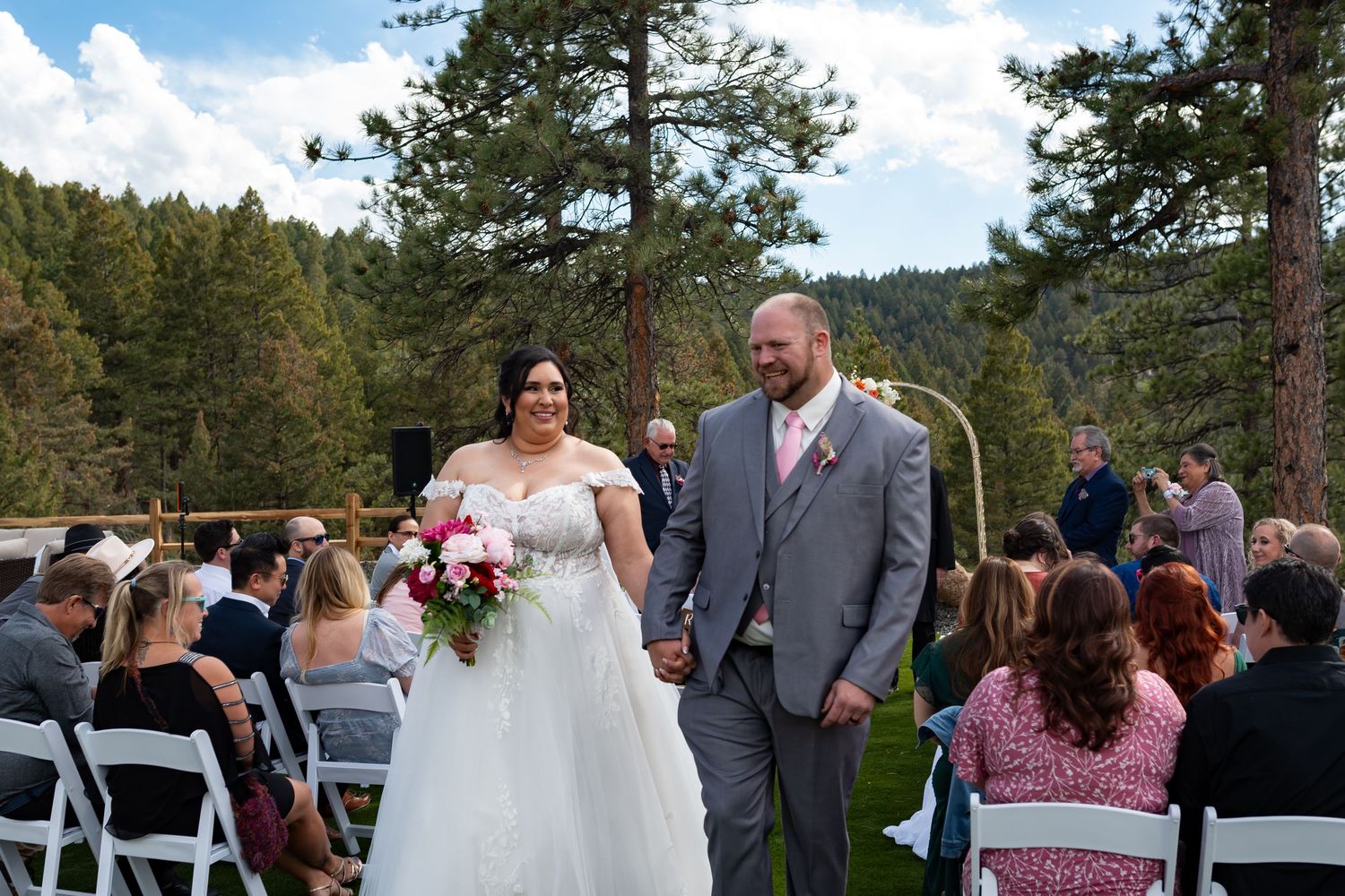 Outdoor wedding ceremony setup with mountain landscape backdrop.
