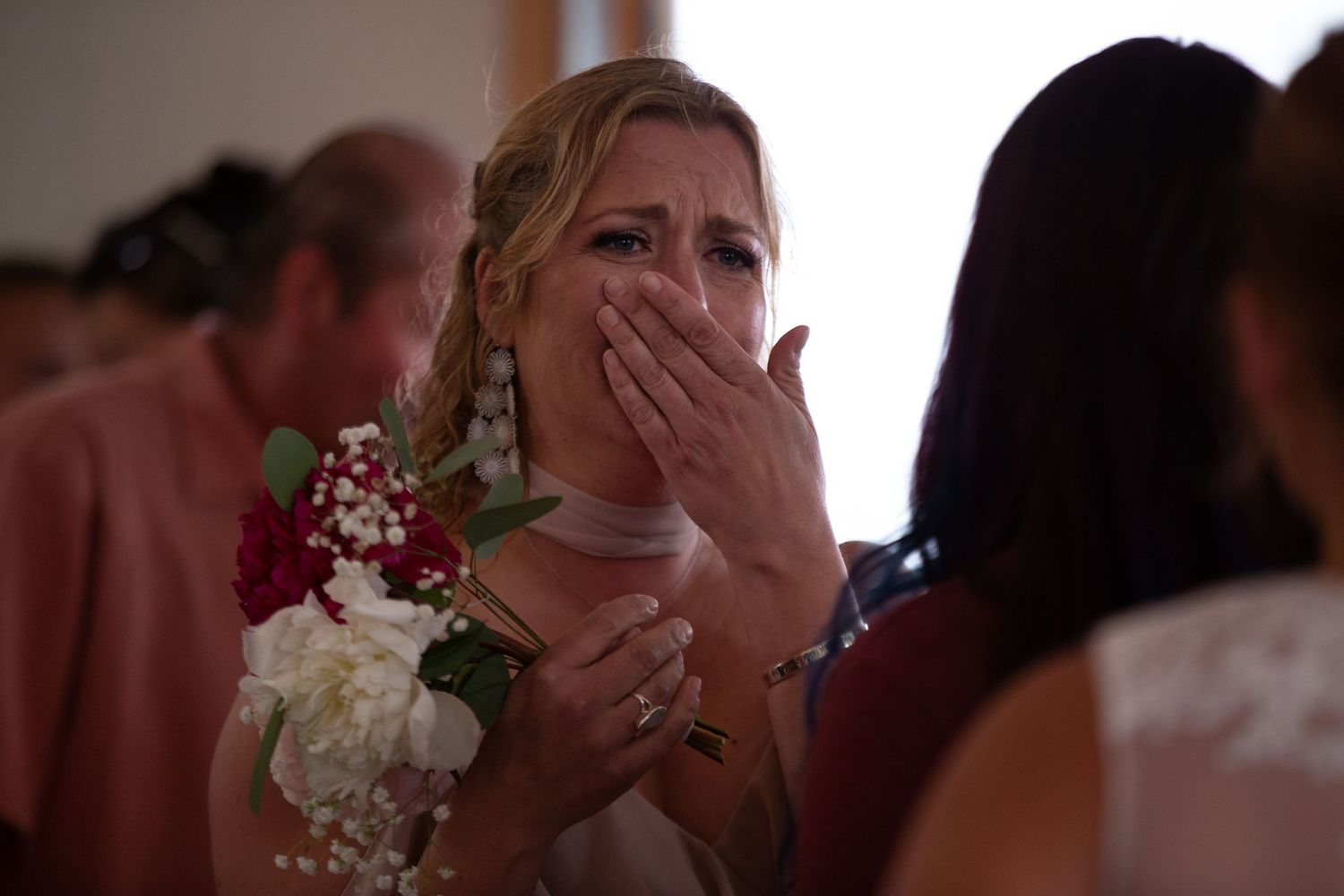 Wedding attendees reacting emotionally during an indoor celebration.