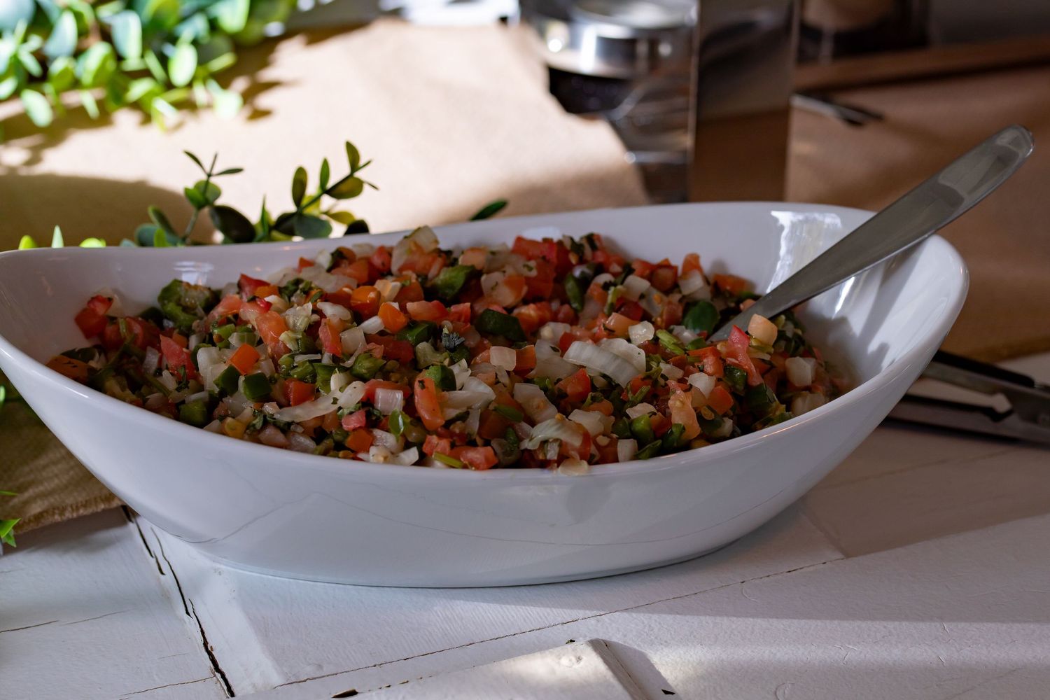 Large white serving bowl filled with colorful mixed vegetable and grain salad.