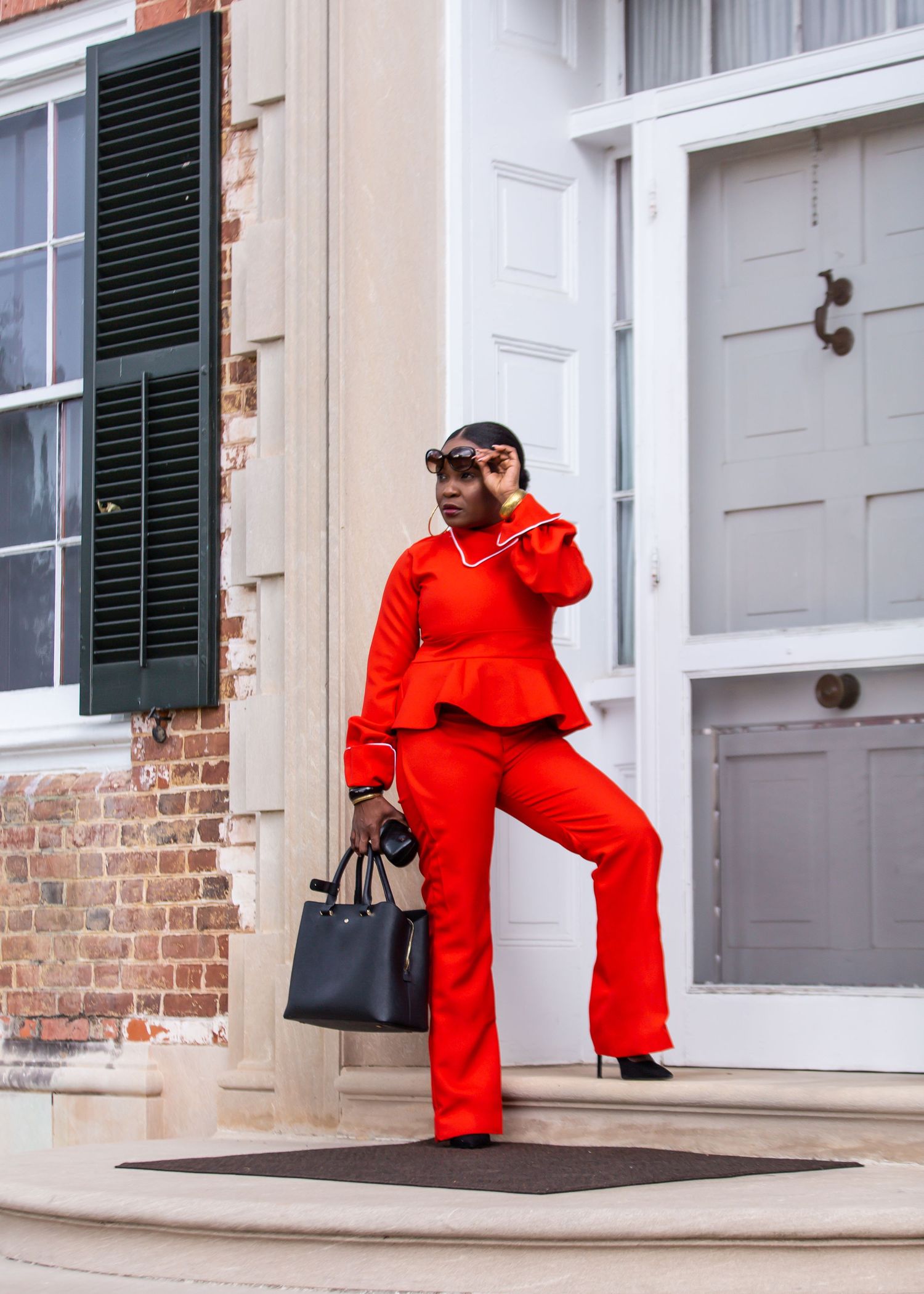 Stylish and fashionable outfit featuring bright red matching set and black handbag on city doorstep made and modeled by VChick Designs.