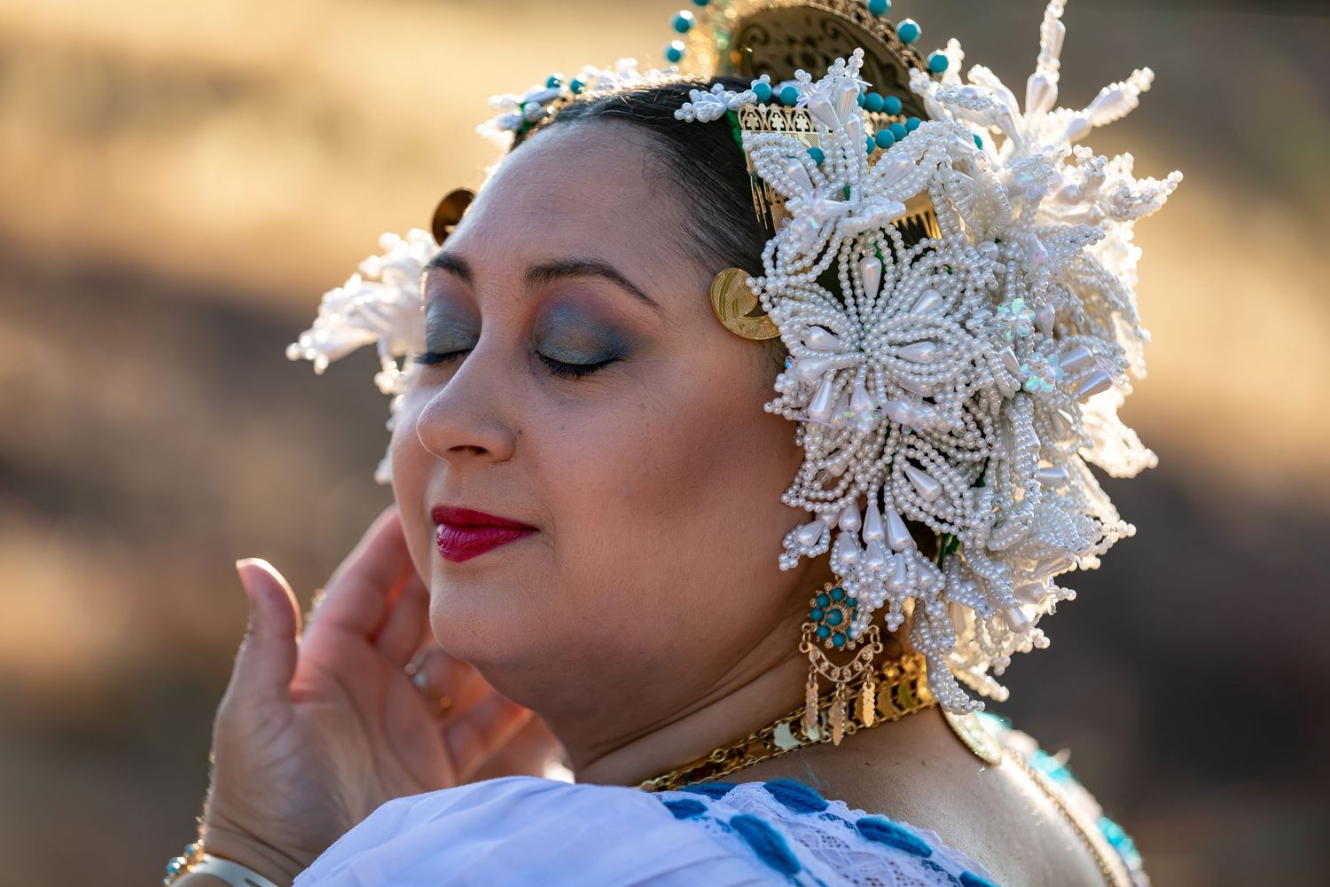 Close-up of dancer wearing ornate floral headpiece and traditional costume during sunset performance.