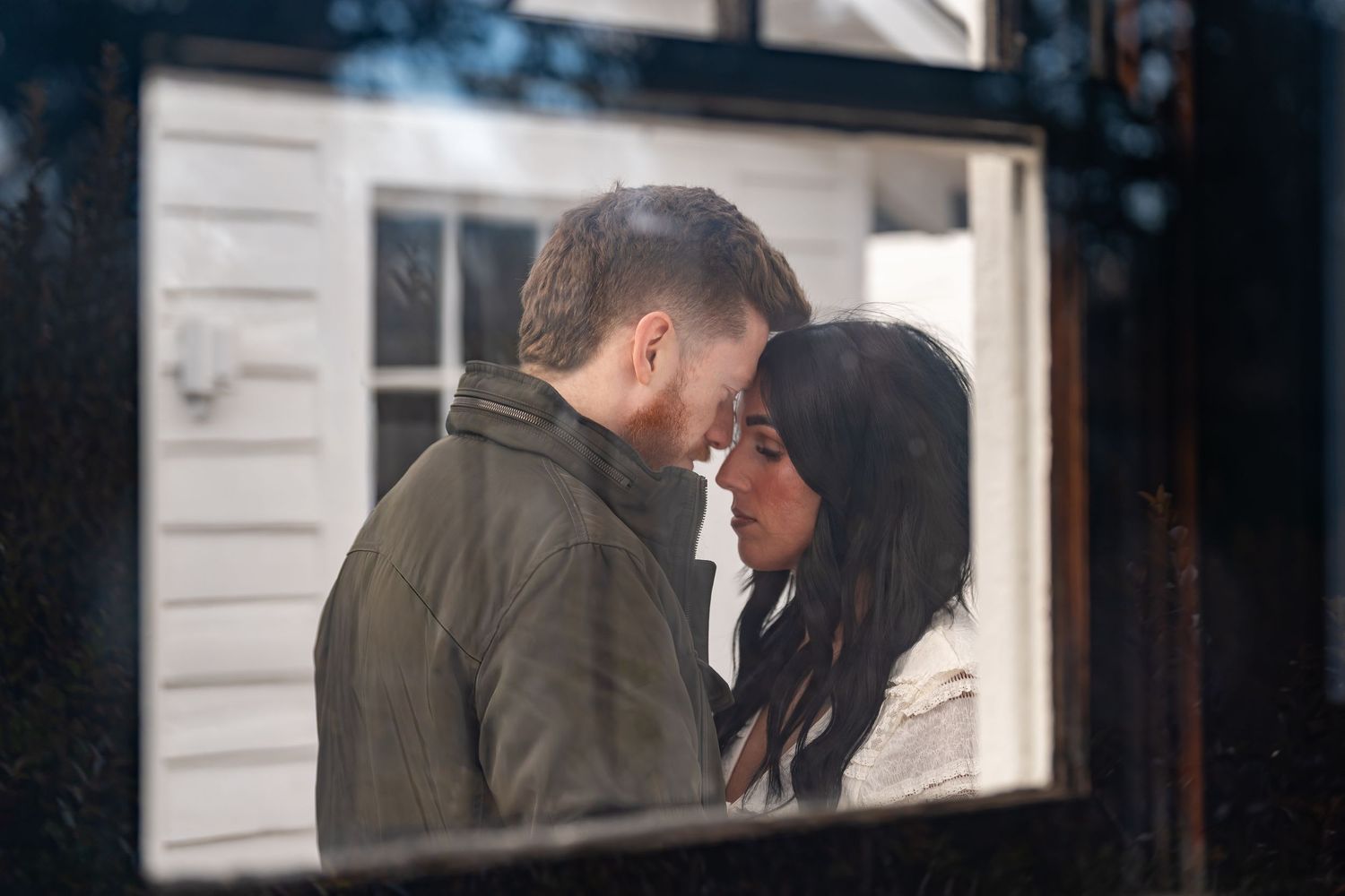 An intimate moment captured through a window frame at dusk.