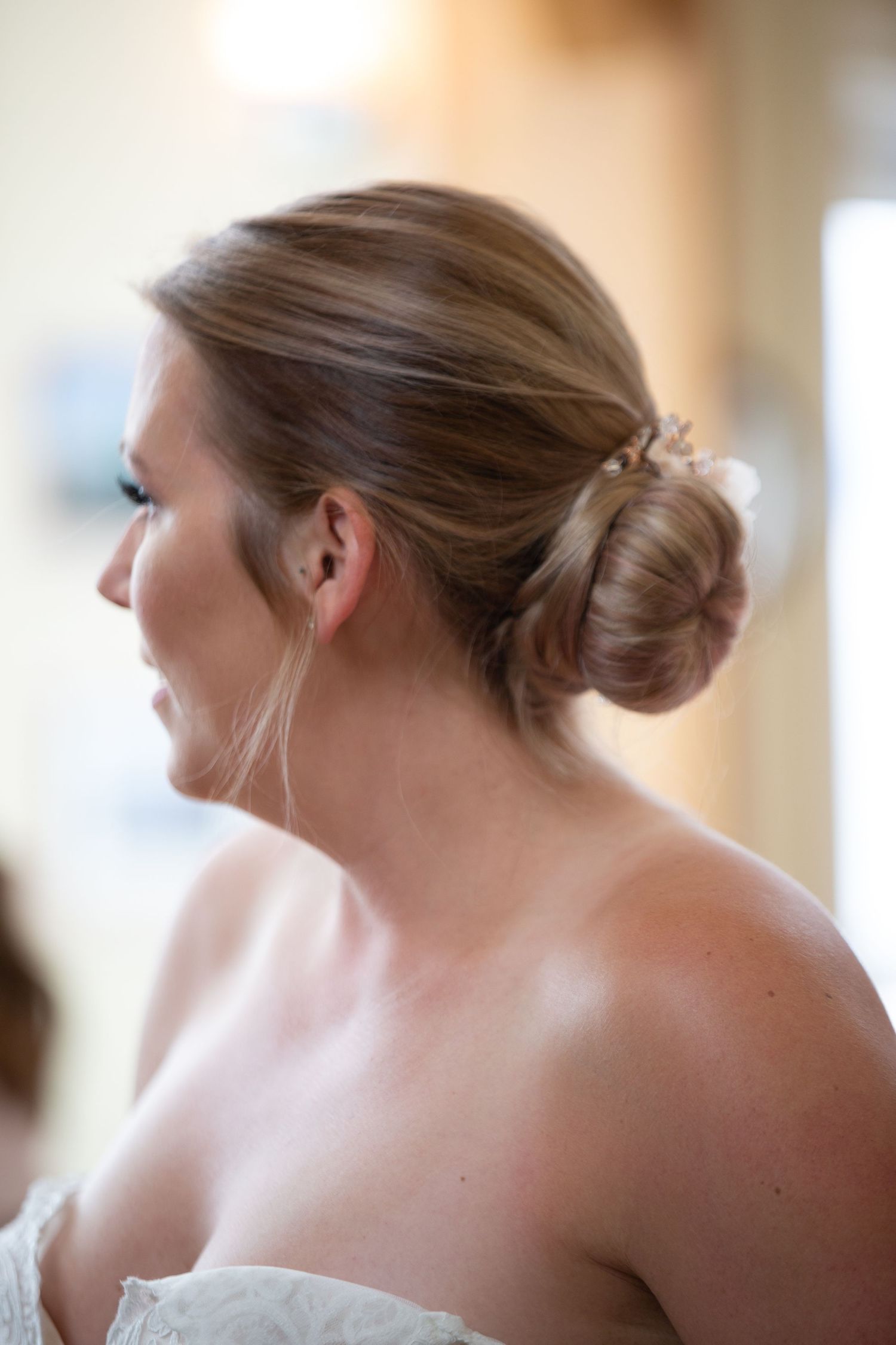 Bride getting her hair and makeup done during wedding preparations.