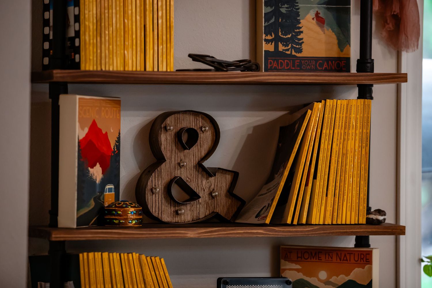 Wooden shelves displaying yellow books and a decorative ampersand symbol.