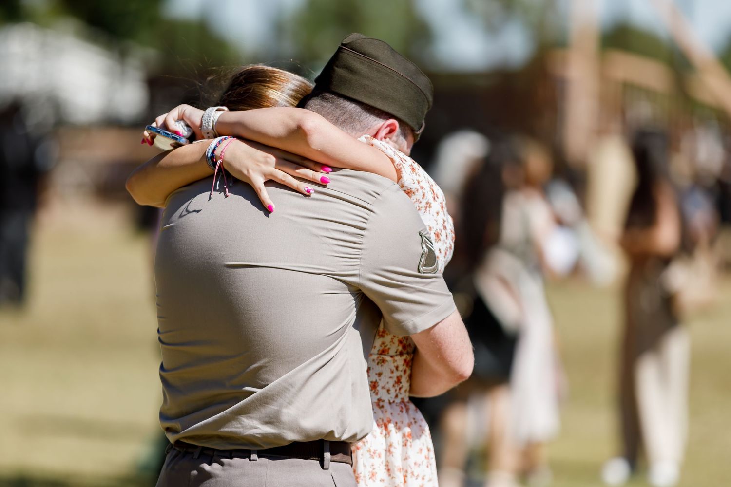 Military personnel embrace family members during an emotional homecoming reunion.