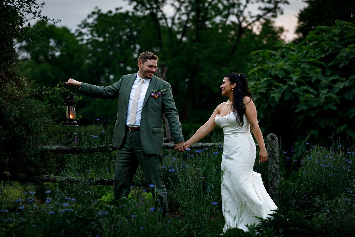 Romantic couple dances together at sunset in a lush garden setting.
