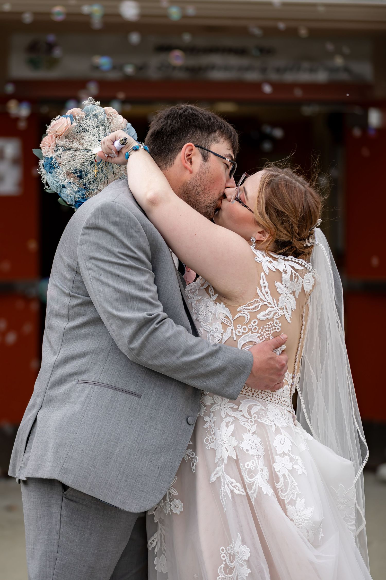 An intimate wedding kiss captured indoors with soft lighting.