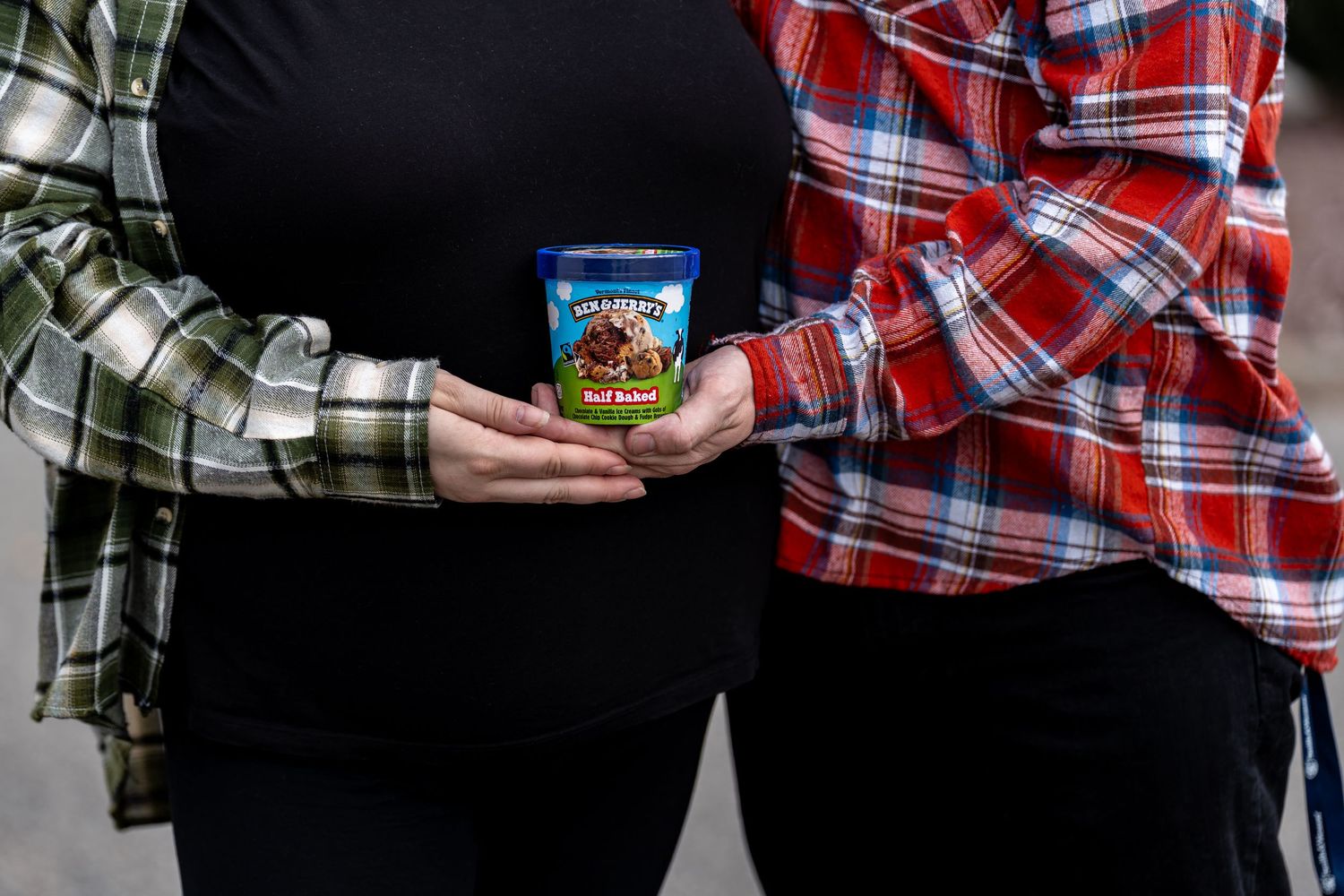 Two people sharing Ben & Jerry's ice cream while sitting together.