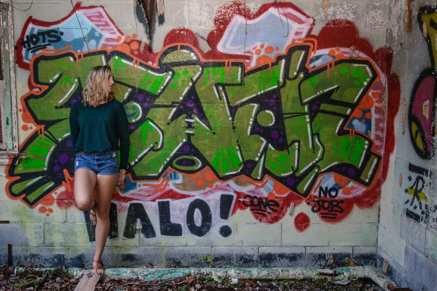 Colorful graffiti art covers concrete walls in an abandoned urban space with debris and rubble.