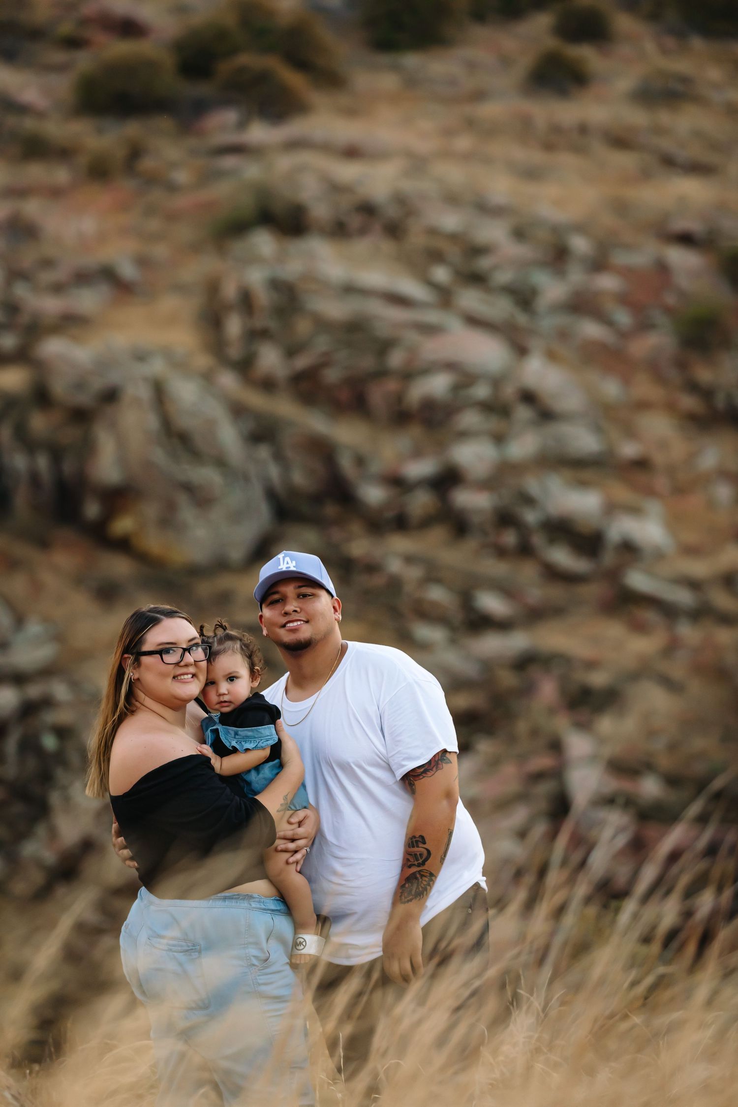 Family portrait session with natural expressions against a rocky desert backdrop.