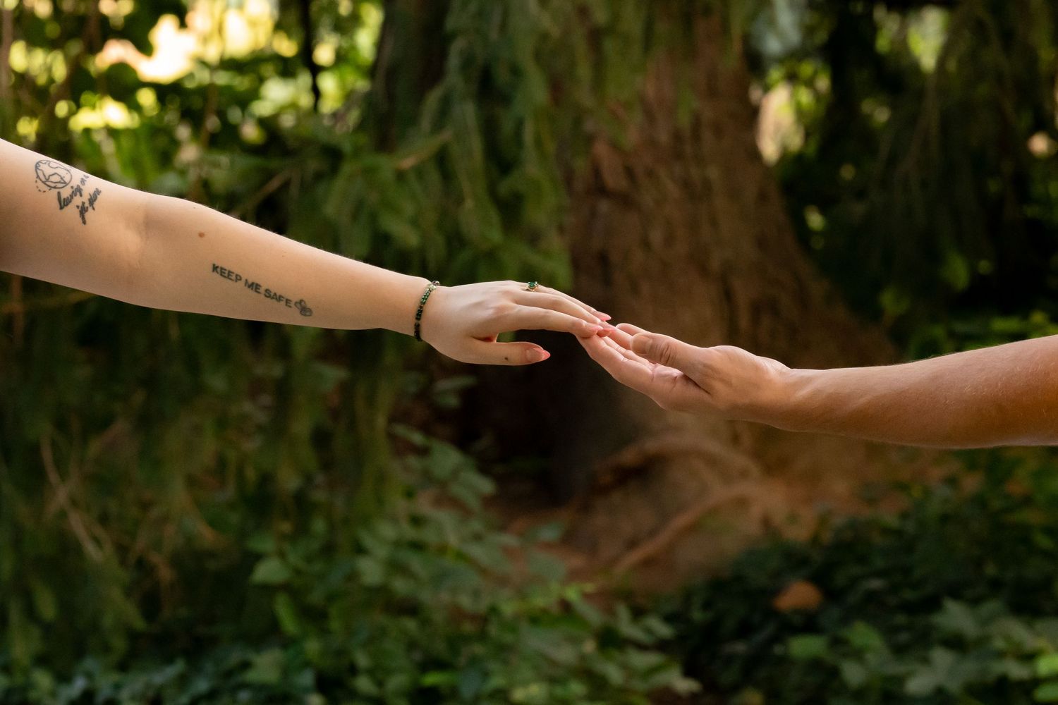 Close-up shots of hands exchanging rings during an outdoor wedding ceremony.