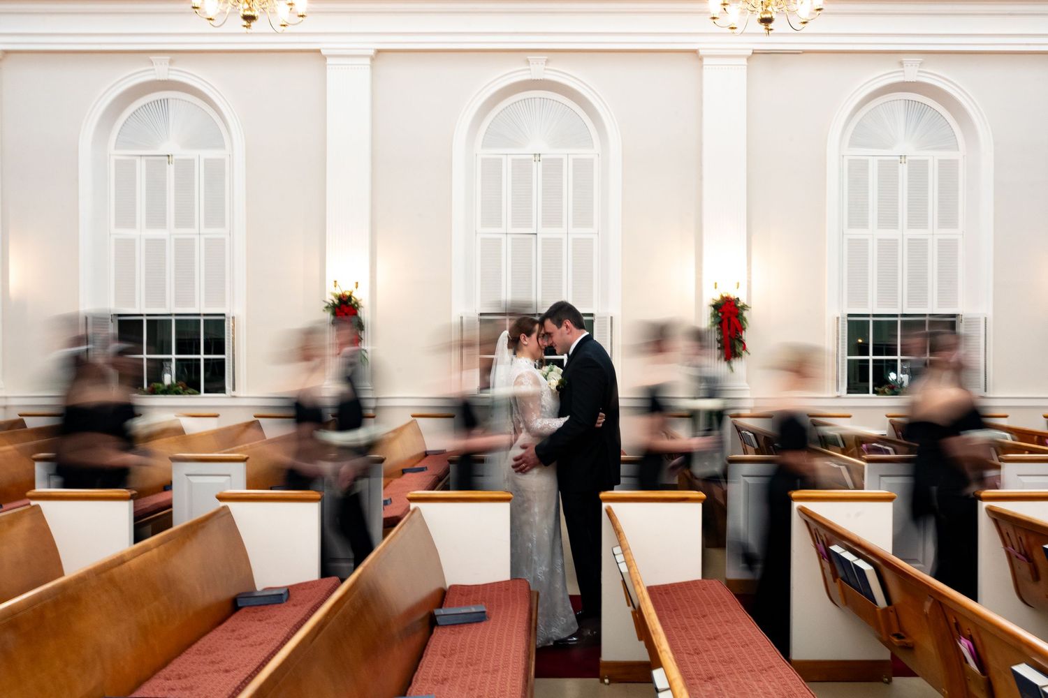 Elegant church interior with wooden pews and decorative molding illuminated by natural light.