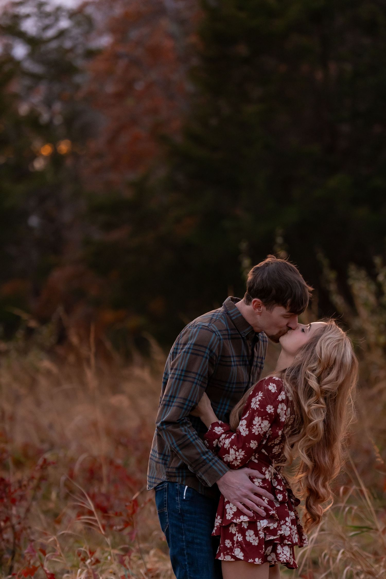 A romantic embrace captured in a rustic autumn setting with golden light.