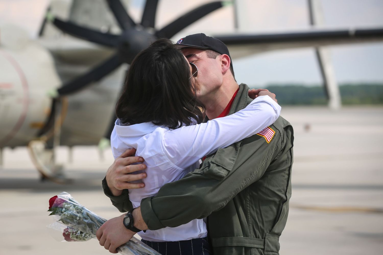 Service members reunite with loved ones on airfield during emotional homecoming.